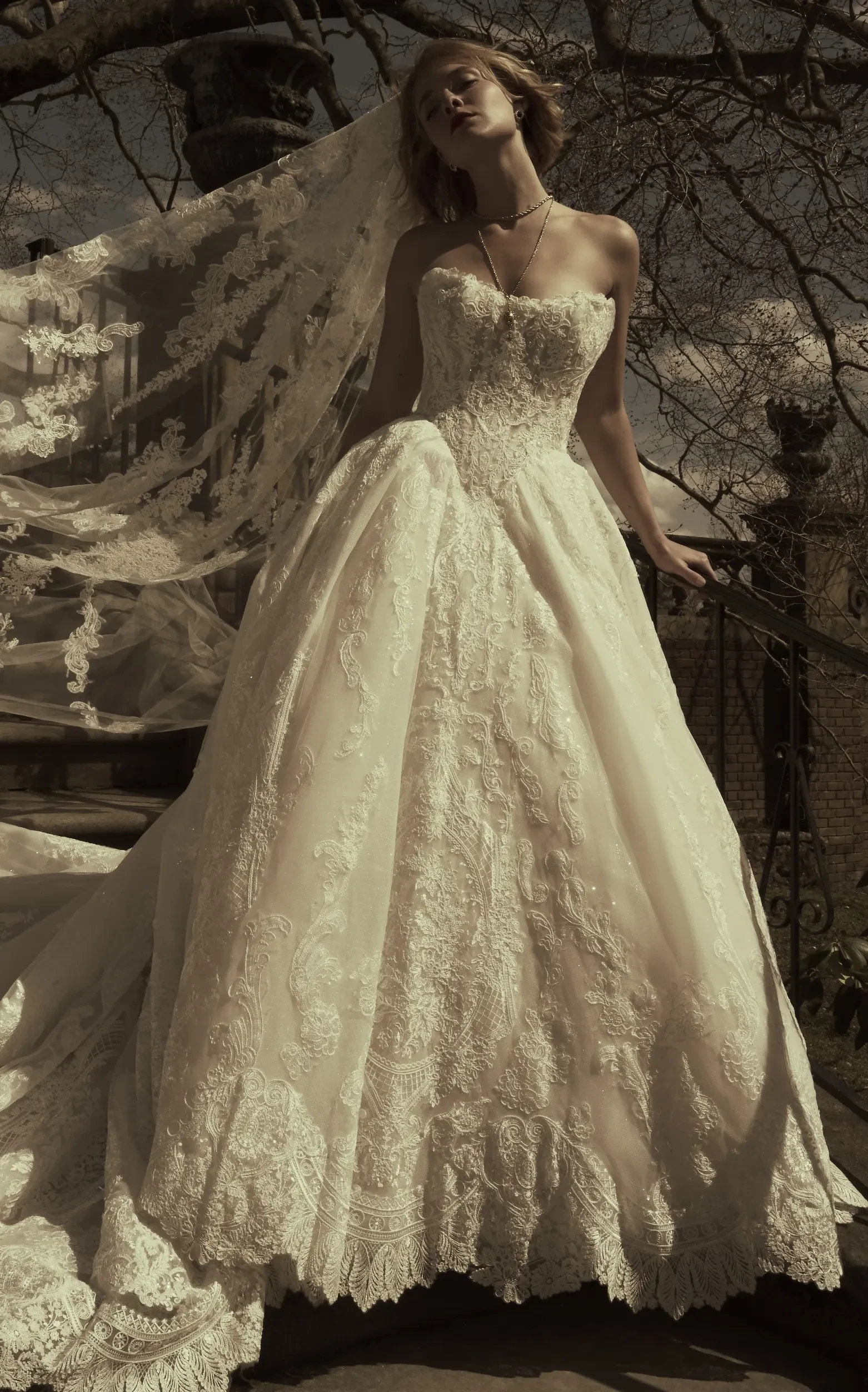 Model Outside Wearing A Veil And A Lace Ballgown Wedding Dress Called Yesenia