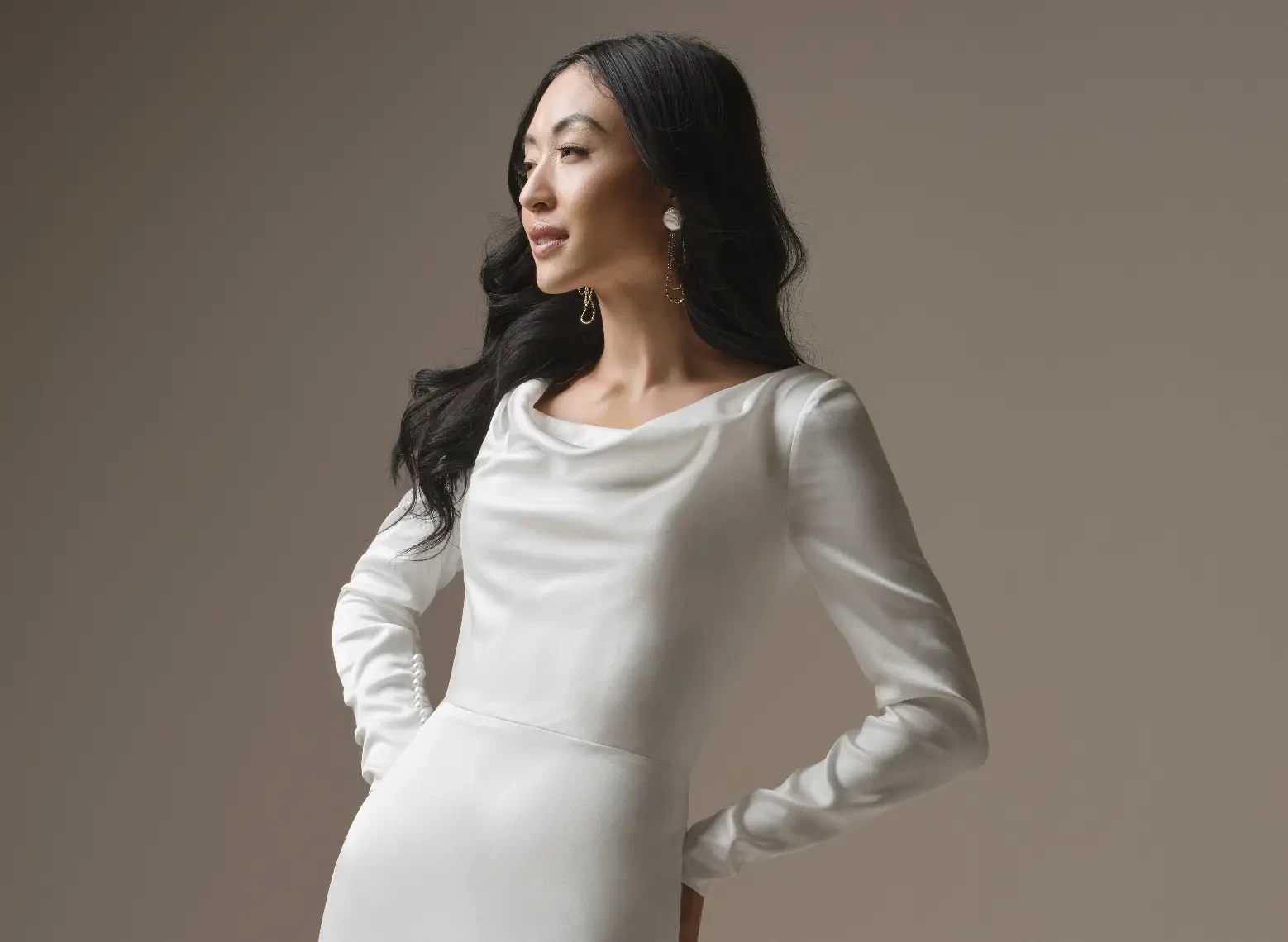 Model In A Studio Wearing Simple Long Sleeve Wedding Dress Called Melinda By Maggie Sottero