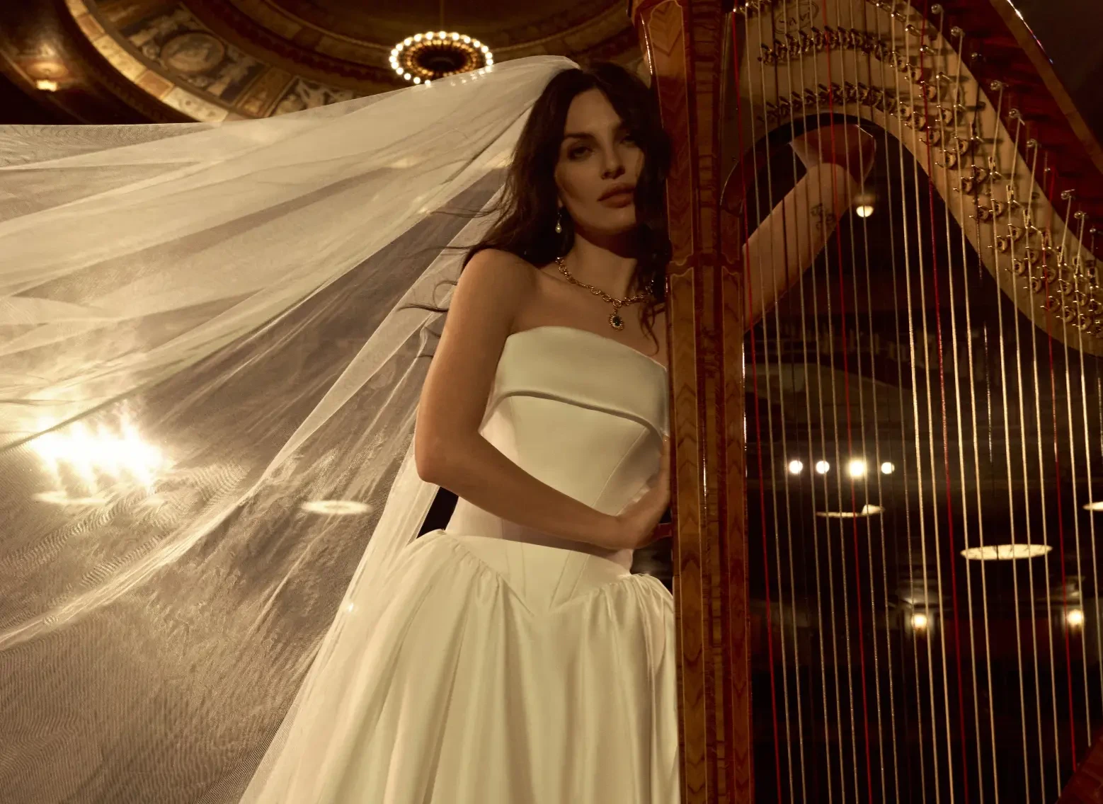 Model Wearing Simple A-line Wedding Dress Called Rane By Maggie Sottero Next To A Harp