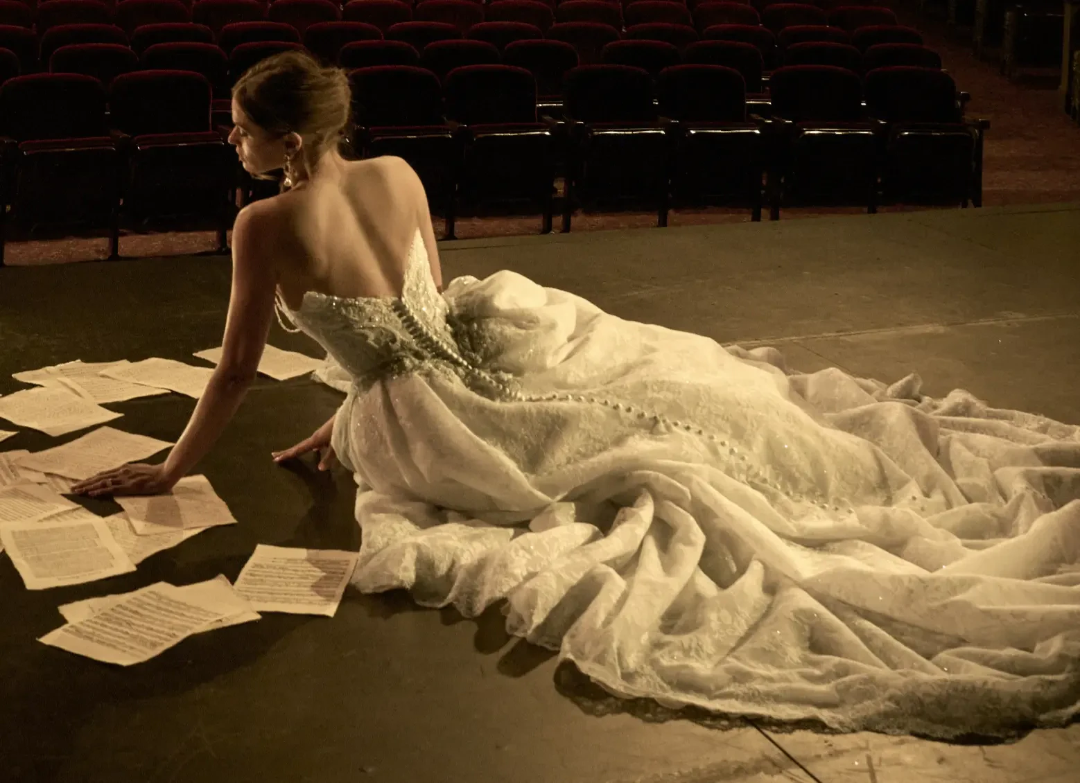 Model Sitting Next To Sheet Music Wearing Lace Ballgown Wedding Dress Called Ryland By Maggie Sottero