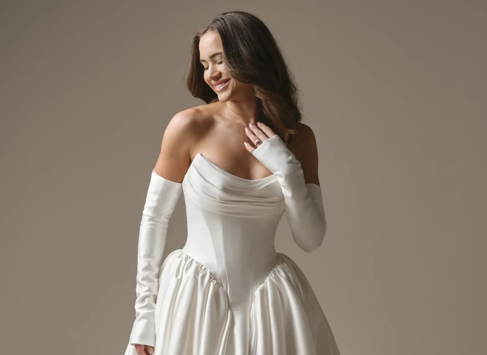 Model In A Studio Wearing Satin Off The Shoulder Wedding Dress Called Hudson By Maggie Sottero