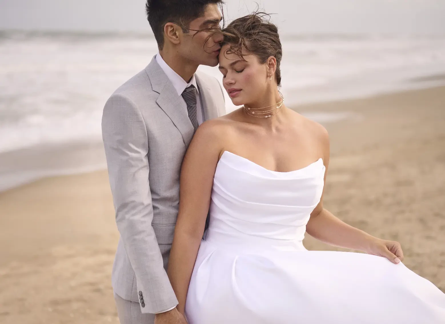 Model Wearing Maureen Wedding Dress With Male Model On A Beach