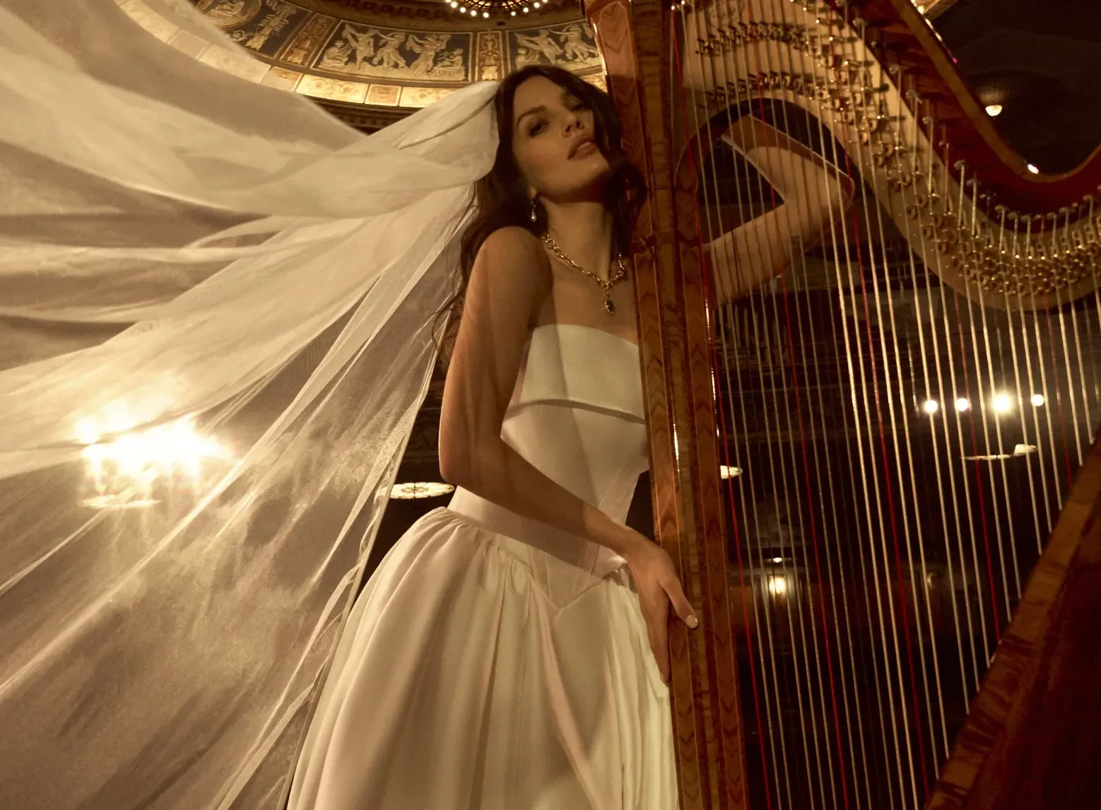 Model In A Theater Next To A Harp Wearing A Simple A-line Wedding Dress Called Rane By Maggie Sottero