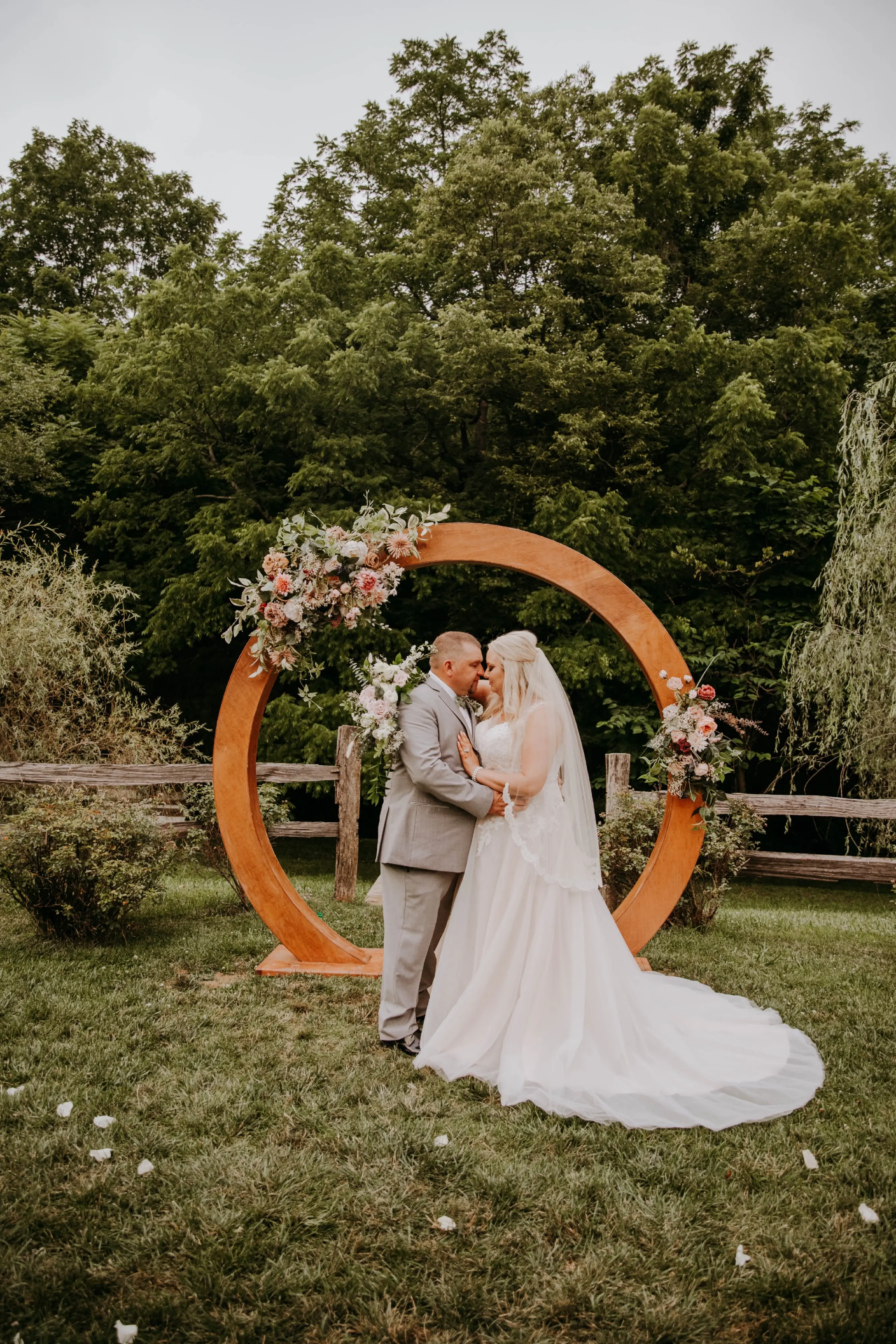 Groom and Bride at an Outdoor Wedding Wearing Lace Ballgown Wedding Dress Called Olivia by Rebecca Ingram