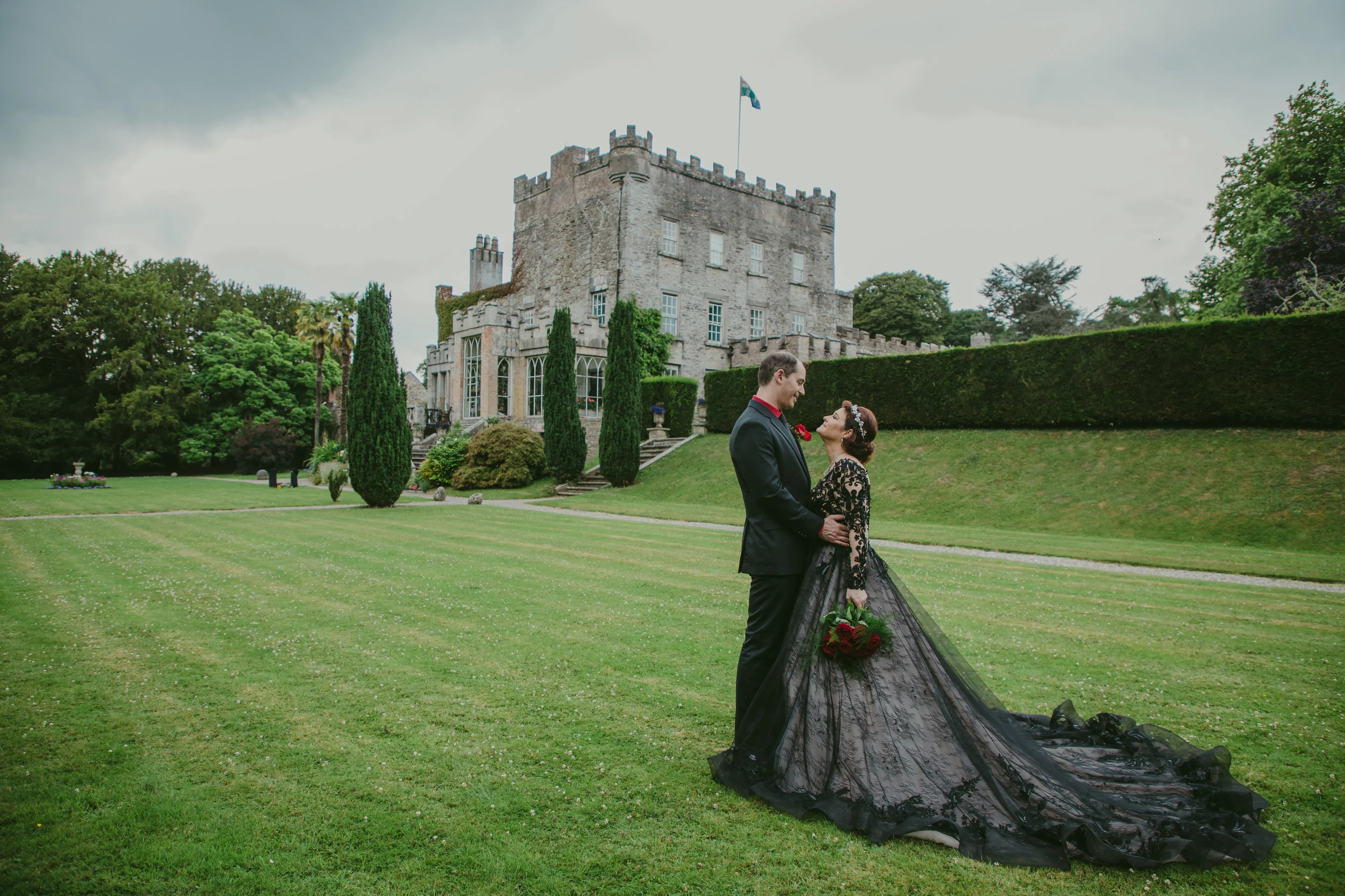 Bride wearing Zander wedding dress by Sottero and Midgley with her groom in front of castle