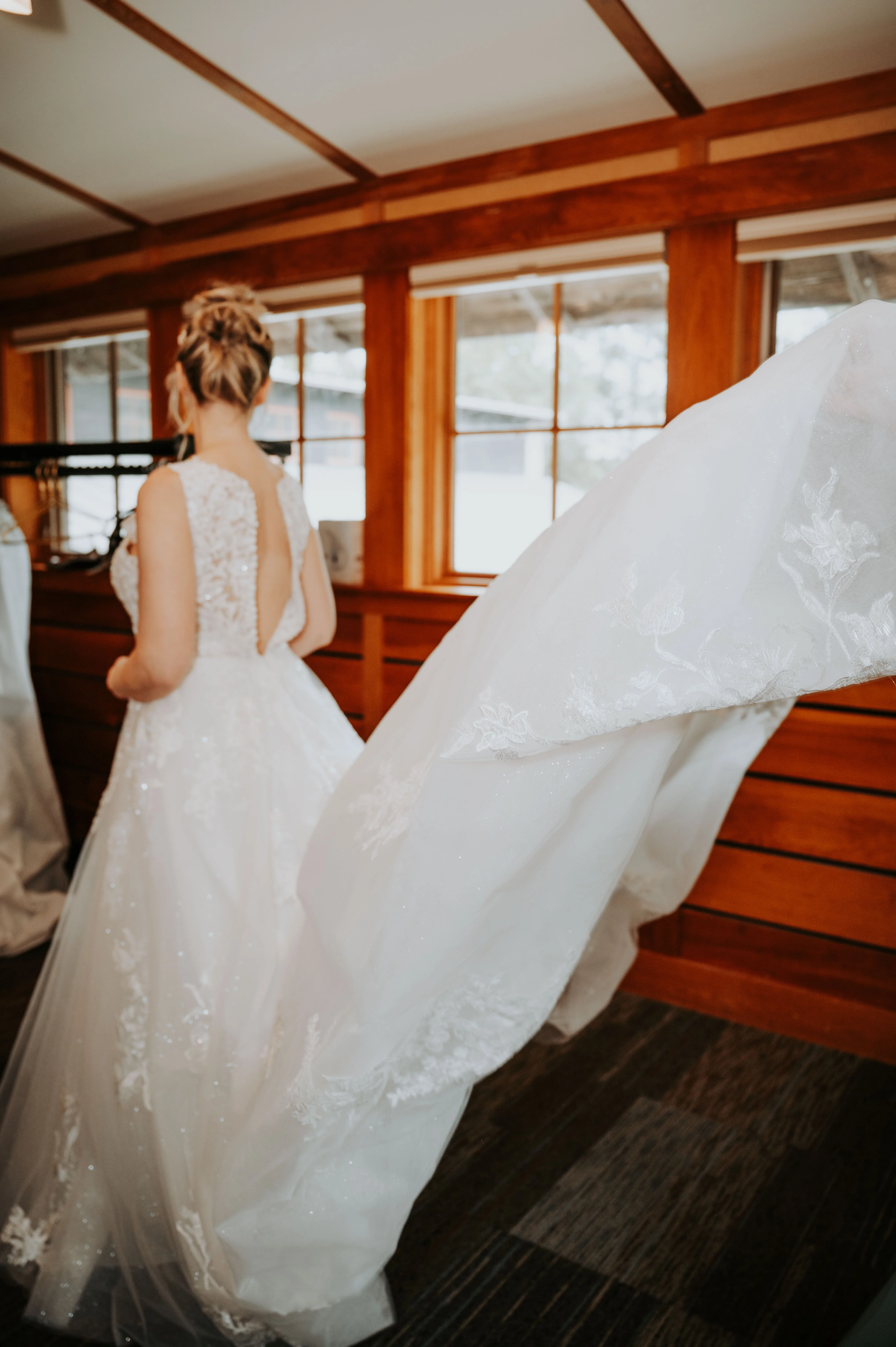 Bride wearing Lace Aline Wedding Dress Called Rickie By Rebecca Ingram With Train In The Air