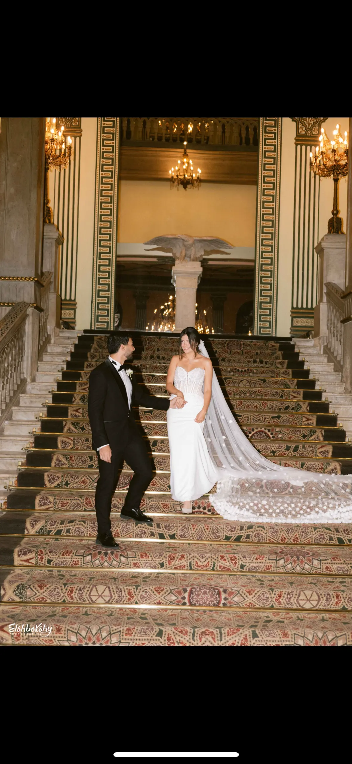 Bride Wearing Sheath and Beaded Wedding Dress Called Doritte By Maggie Sottero Walking Down The Stairs With Groom