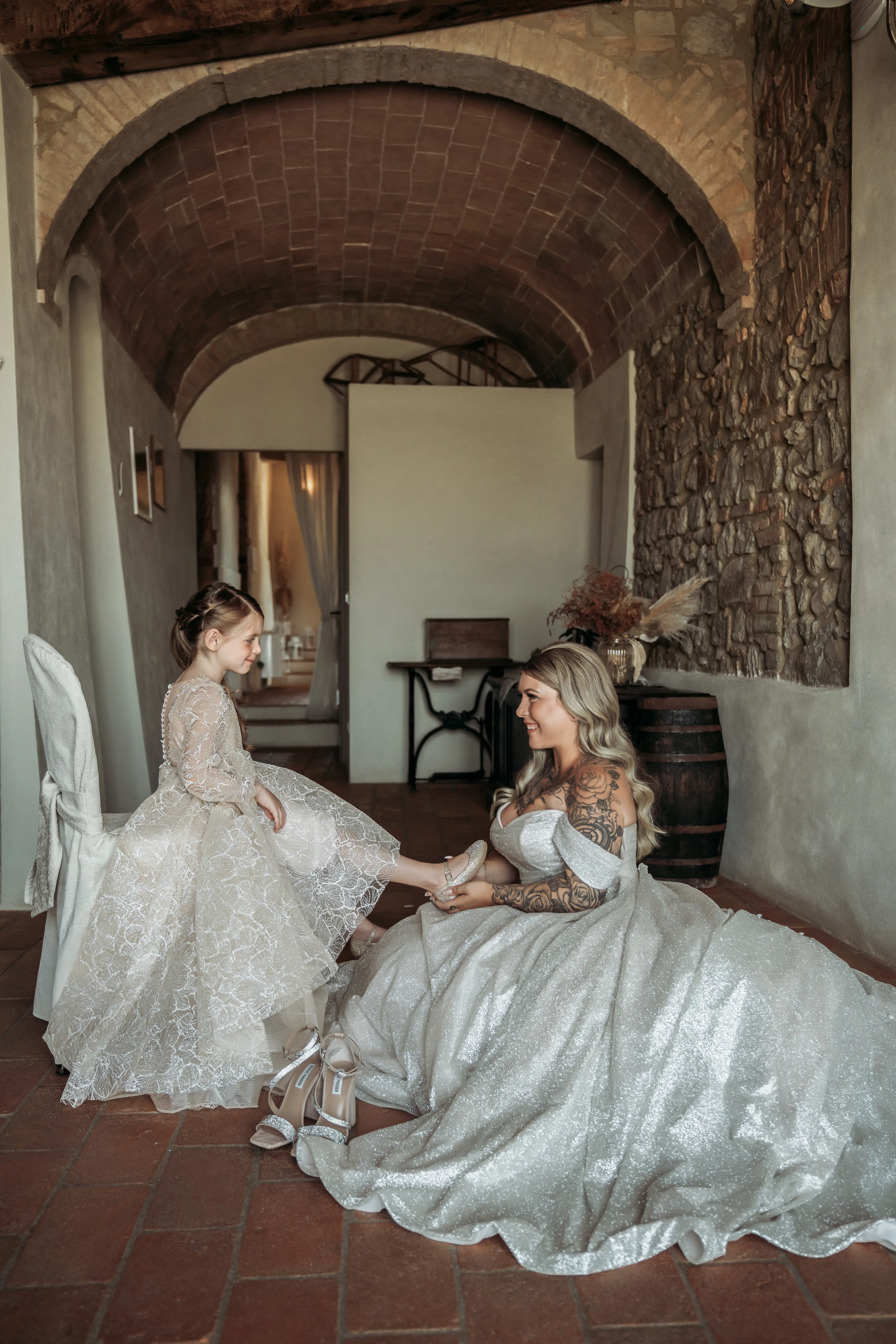 Bride wearing Anniston by Maggie Sottero putting on her flower girl's shoes