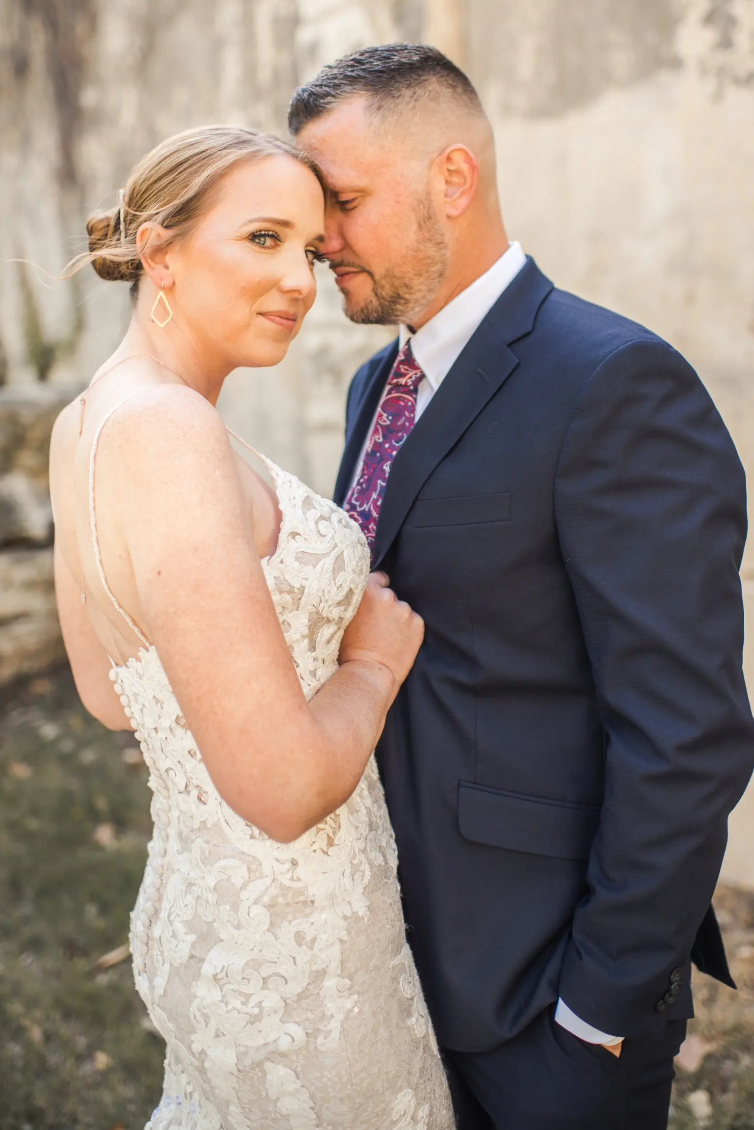 Bride Wearing Glamorous Lace And Sequin Wedding Dress Called Tuscany By Maggie Sottero In Close With Groom Holding Jacket