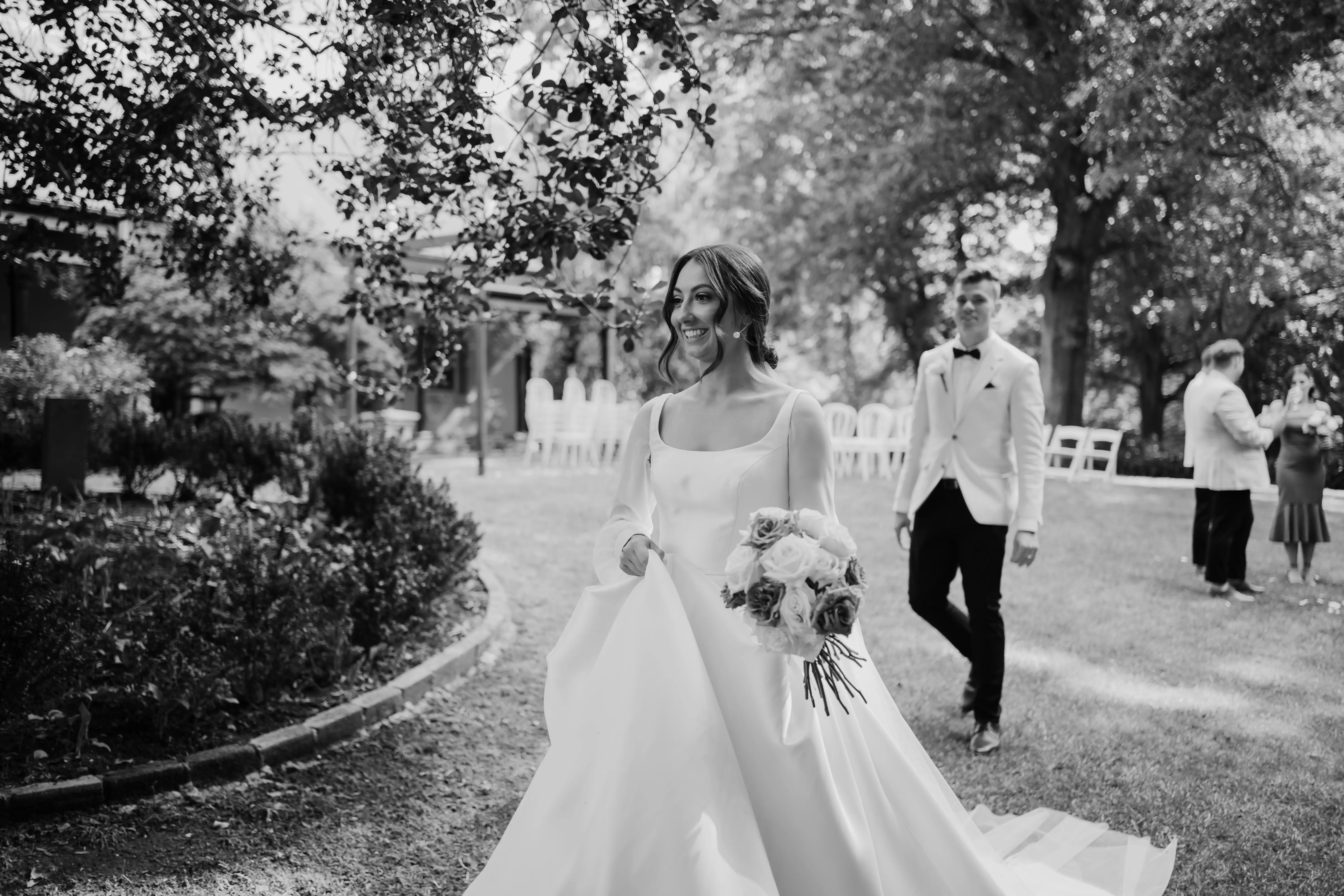 Bride walking away from groom smiling.