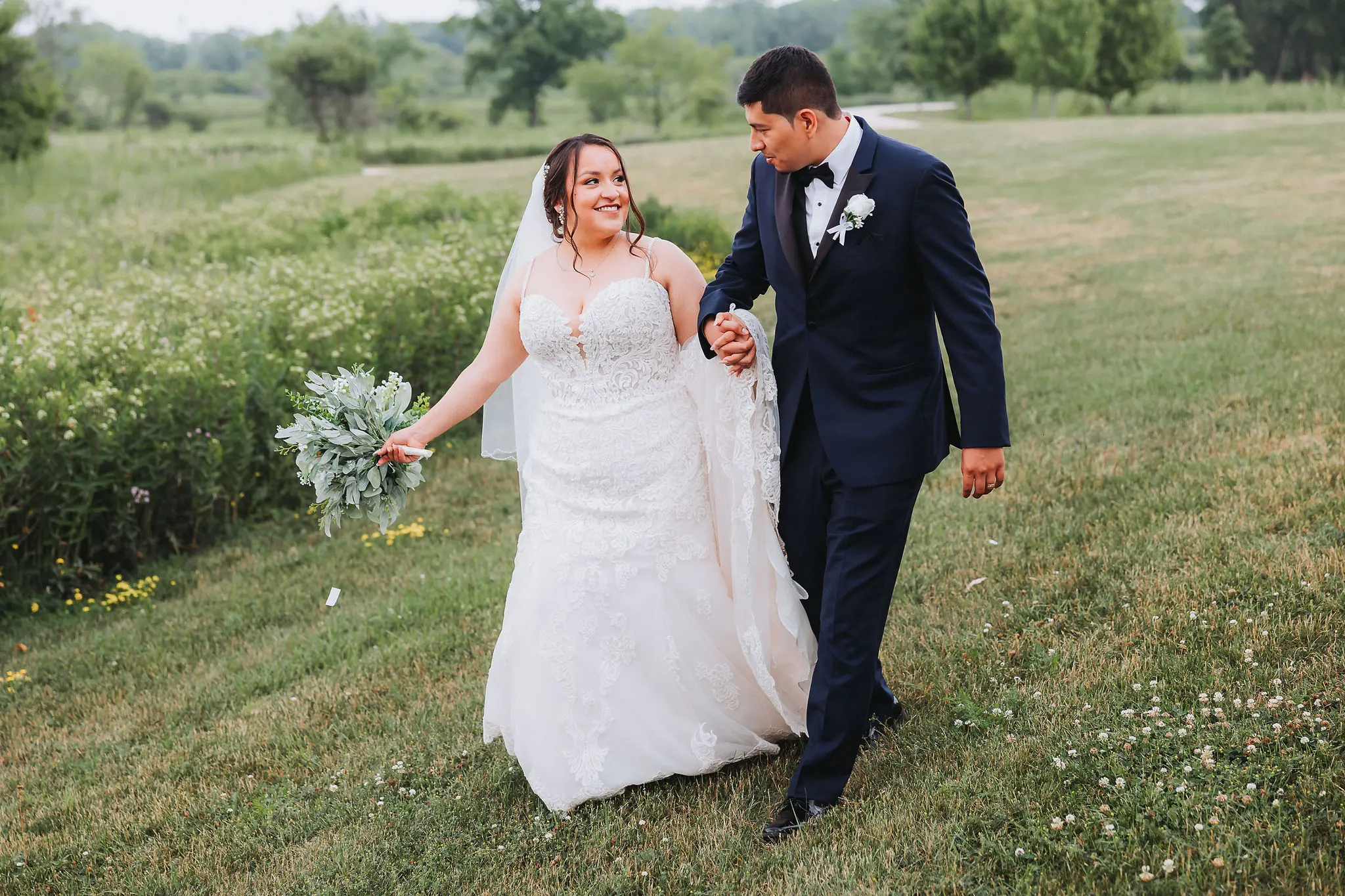 Bride wearing Fiona wedding dress by Maggie Sottero walking with her husband