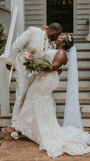Groom dipping bride both wearing light gold and ivory.