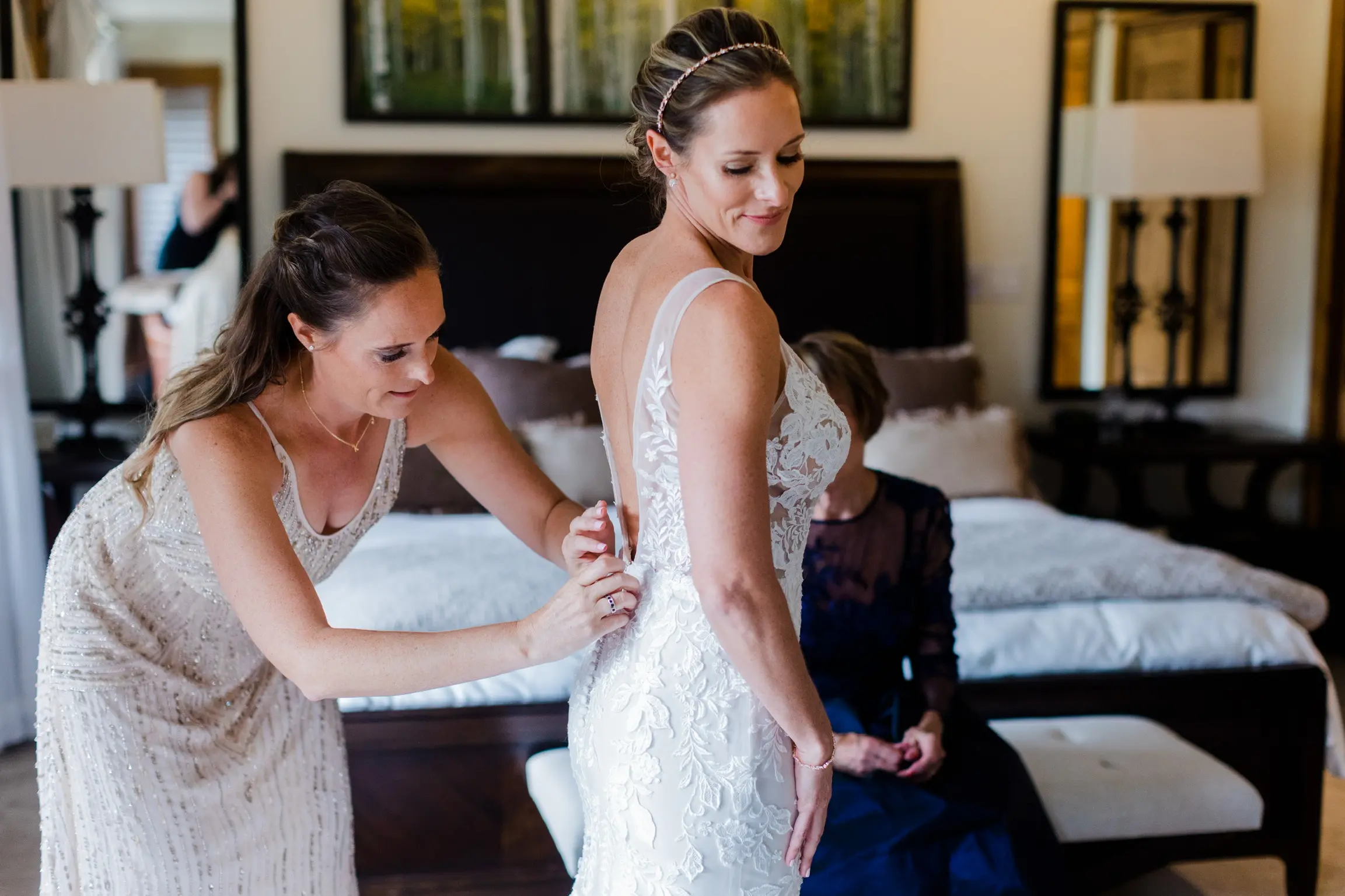 Bridesmaid fastening brides dress called Greenley.
