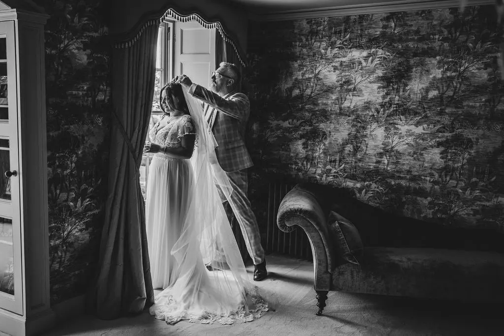 Bride wearing Lorraine by Rebecca Ingram having her veil put on