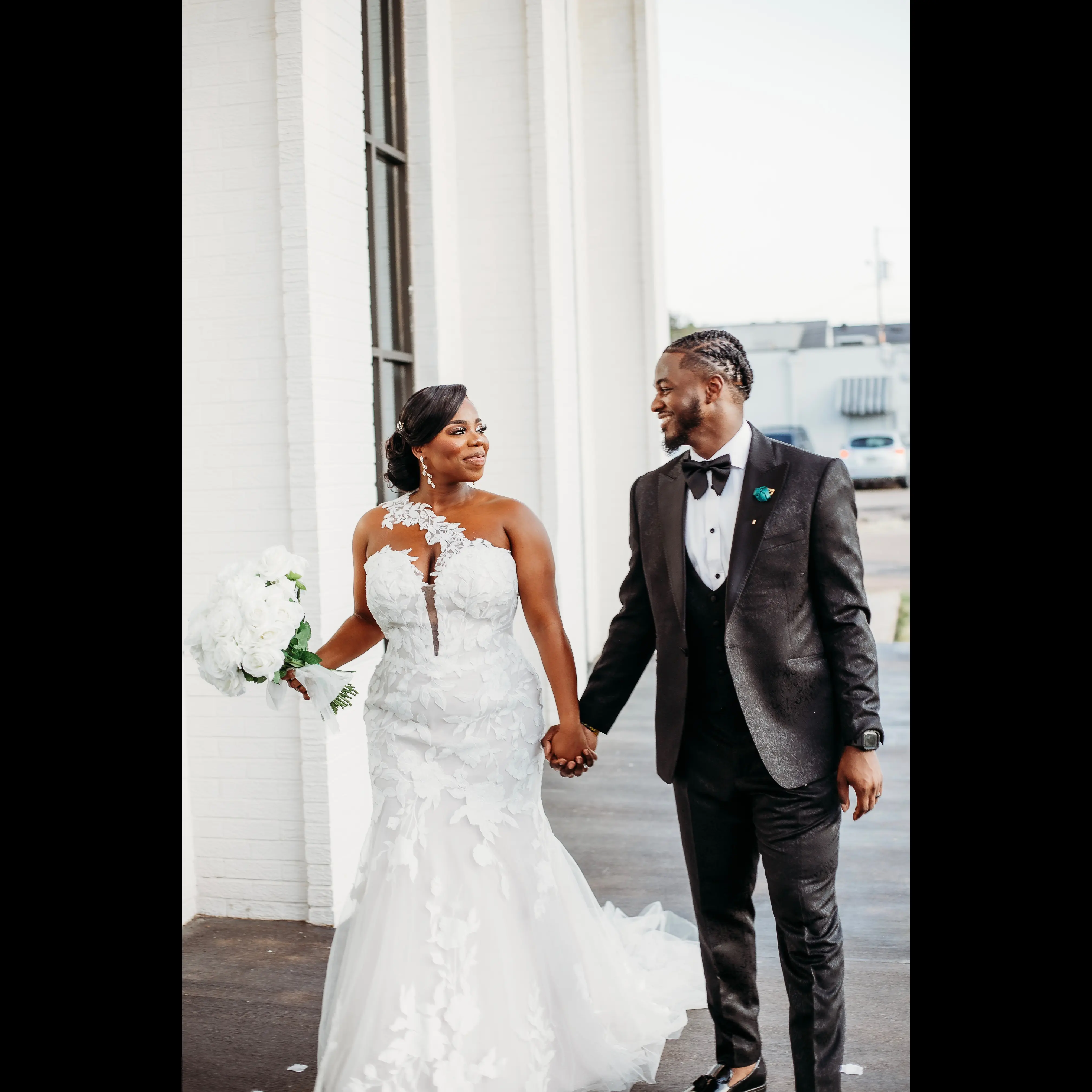 Bride wearing Hattie by Rebecca Ingram holding hands with her husband