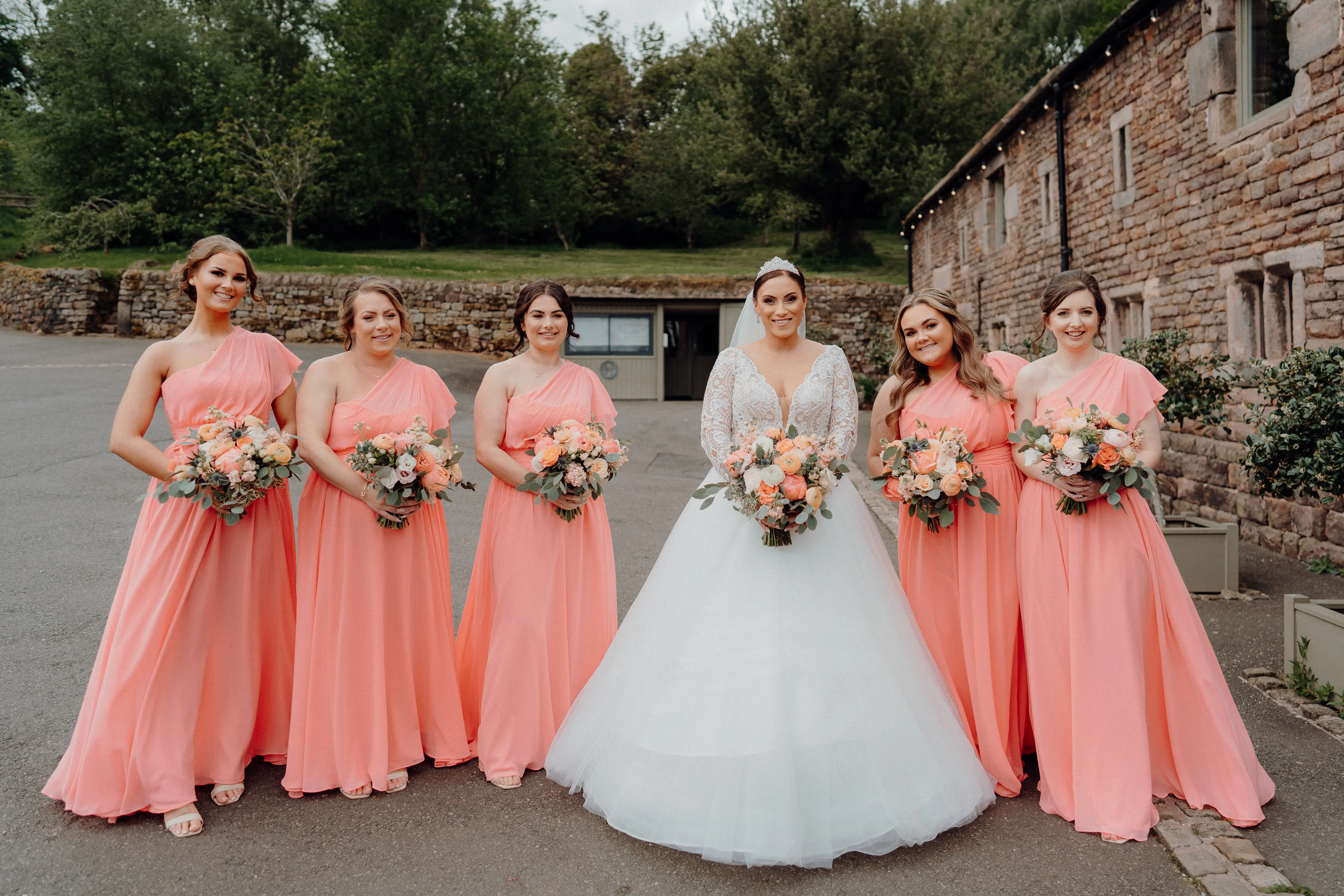 Bride In Long Sleeve Ball Gown Wedding Dress Called Mallory Dawn By Maggie Sottero With Bridesmaids In Pink