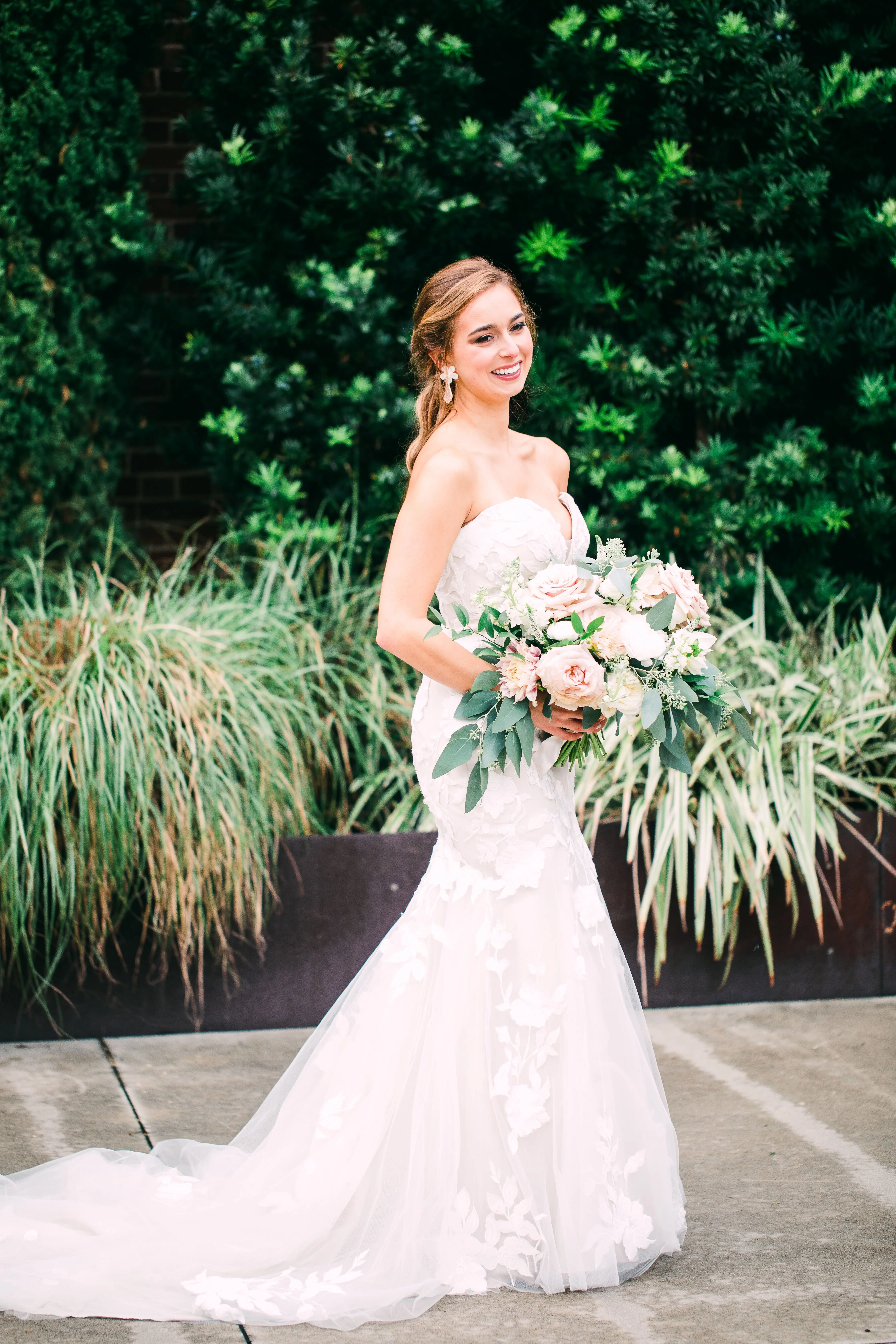 Bride wearing strapless mermaid wedding dress with oversized lace