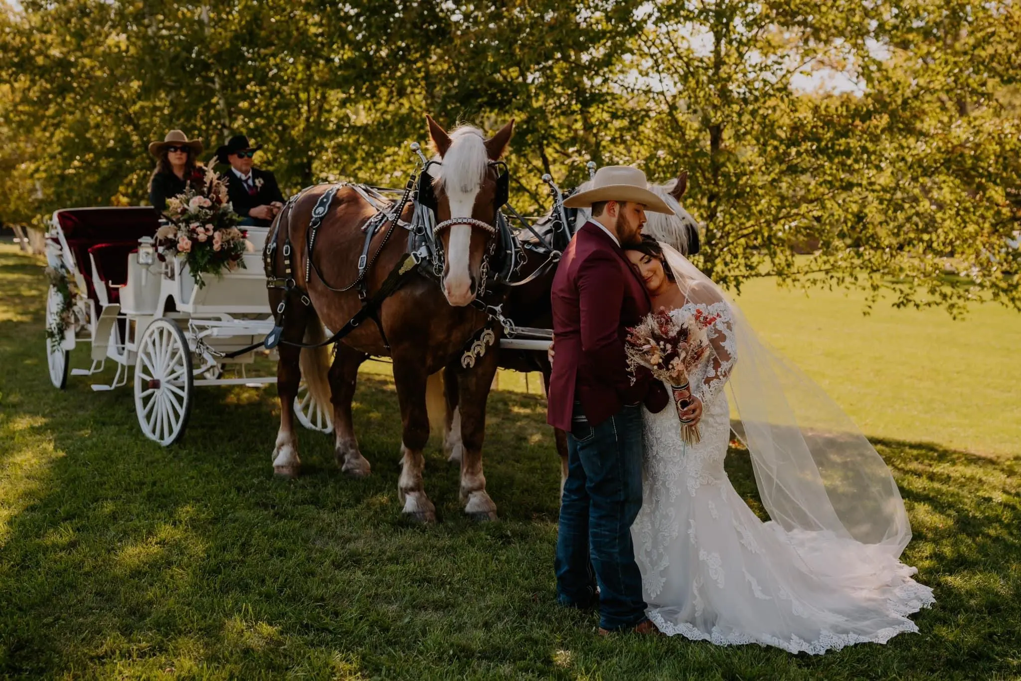 Bride wearing Fiona wedding dress by Maggie Sottero with her husband in front of a horse-drawn carriage