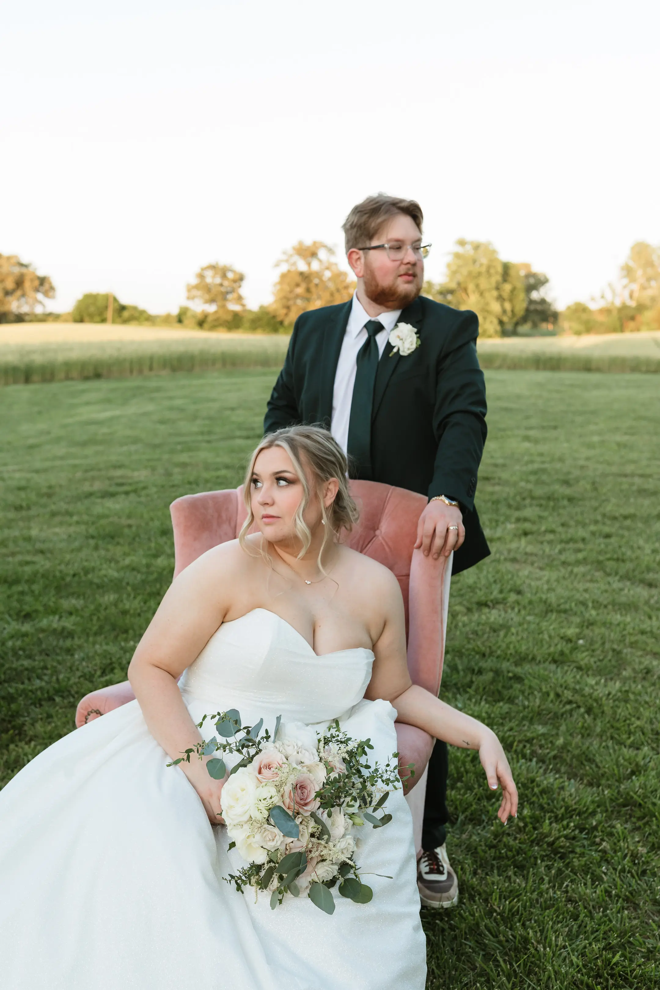 Bride wearing Anniston by Maggie Sottero with her husband sitting on a chair outside
