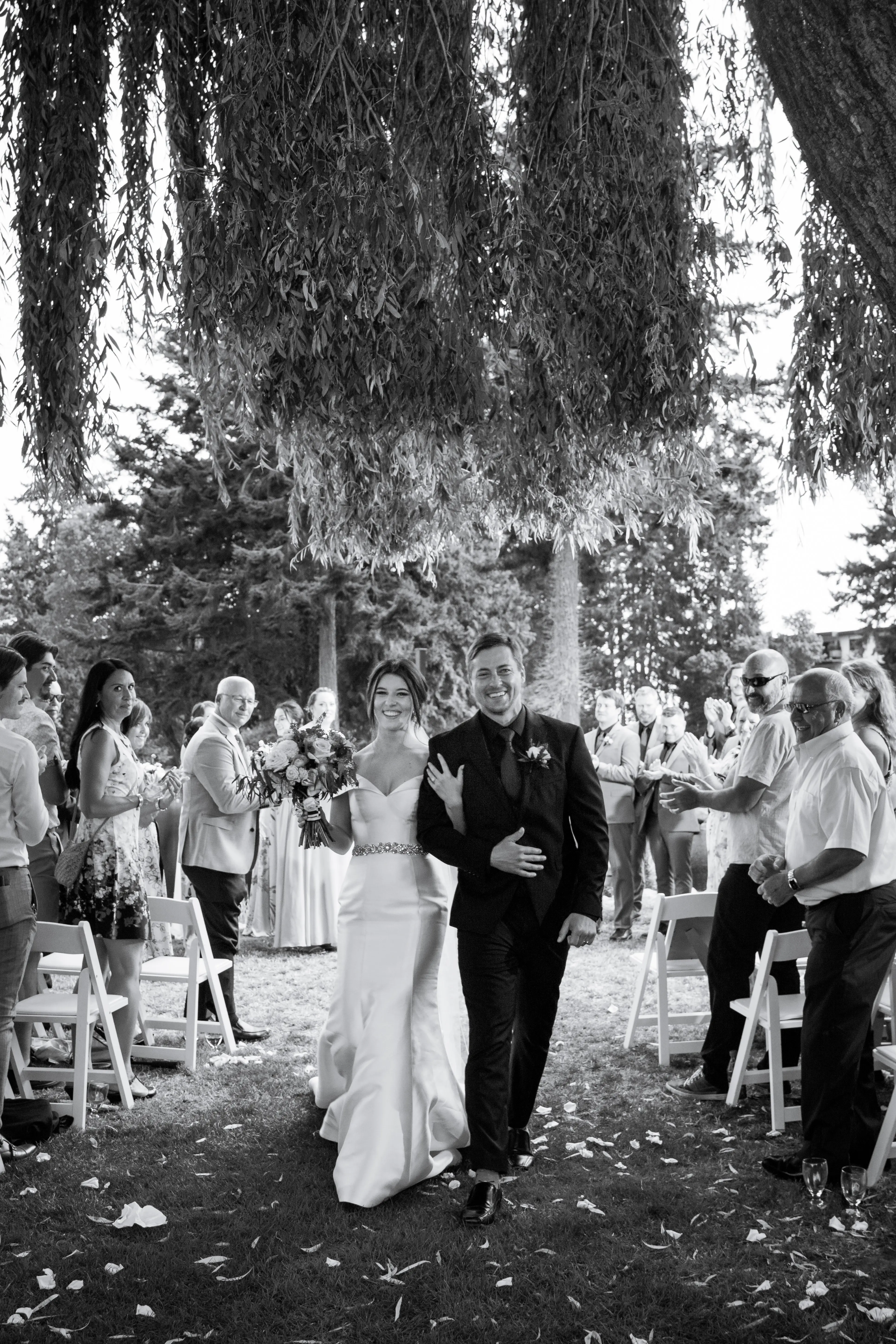Bride Wearing Simple Classic Wedding Gown Called Josie By Rebecca Ingram Walking Down the Aisle With The Groom