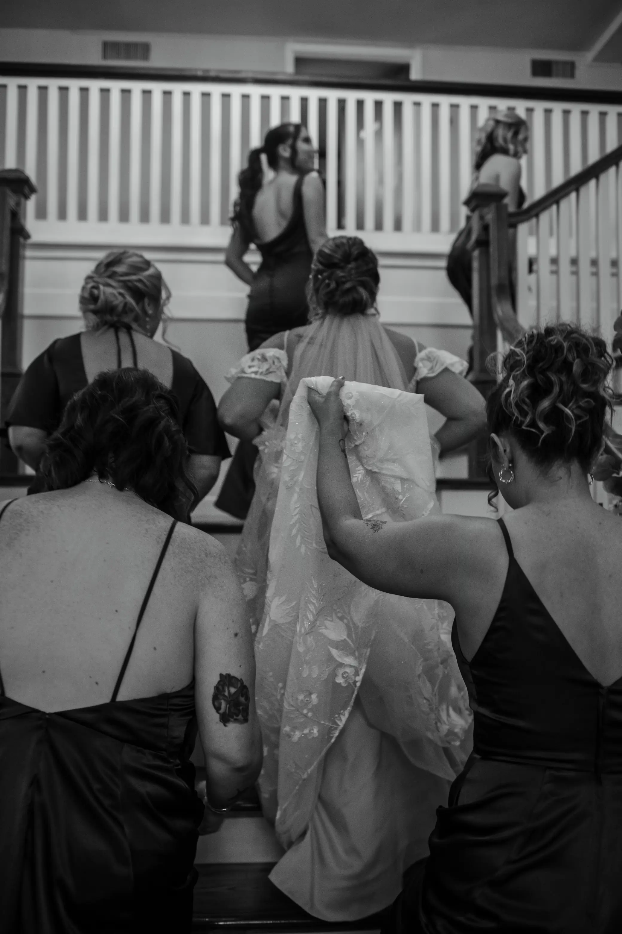 Bride wearing Keisha wedding dress by Maggie Sottero walking up stairs with her bridesmaids