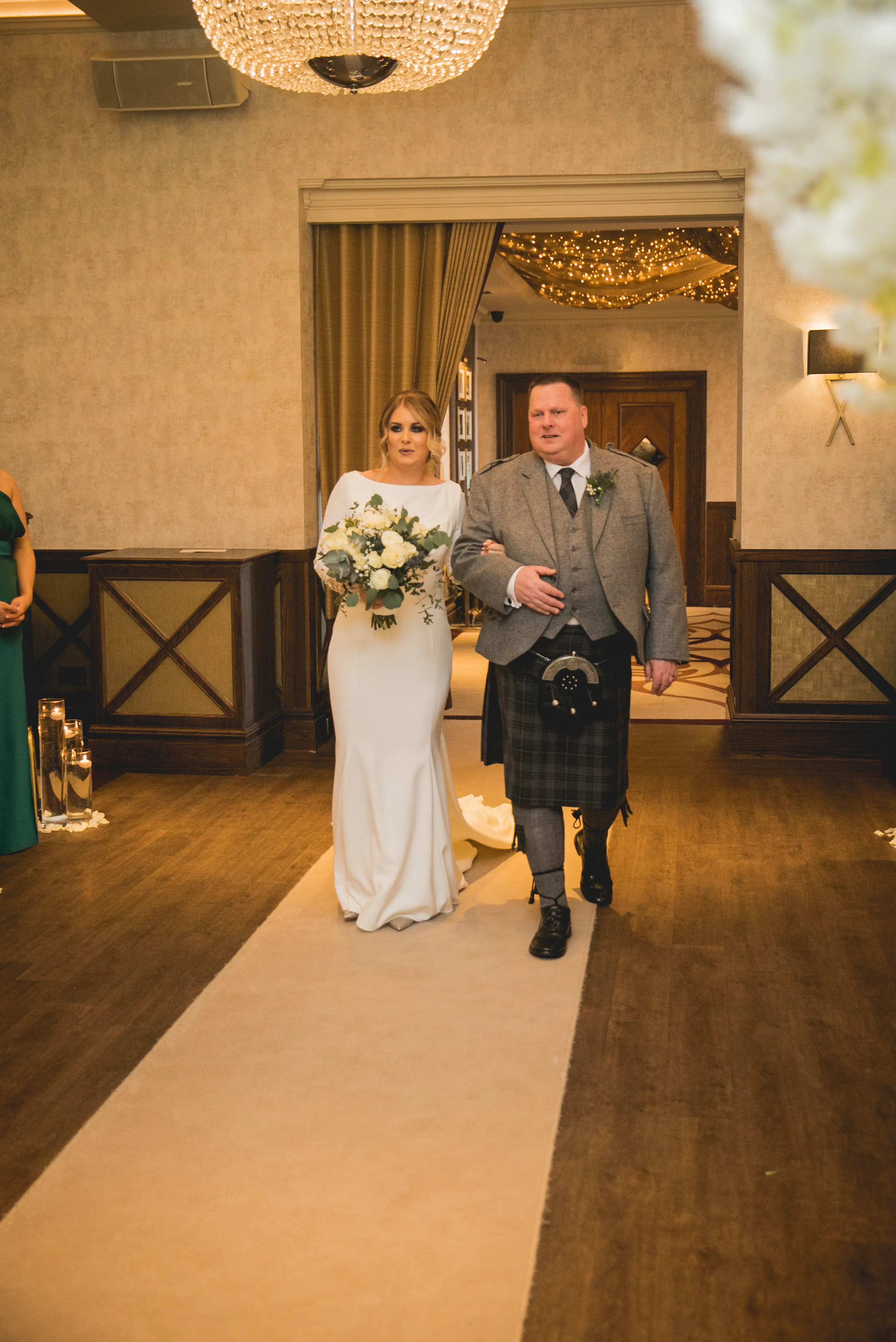 Bride Walking Down Isle in Crepe Fit-and-Flare Wedding Dress with Beaded Illusion Embroidery Featuring Swarovski Crystals Called Aston by Sottero & Midgley