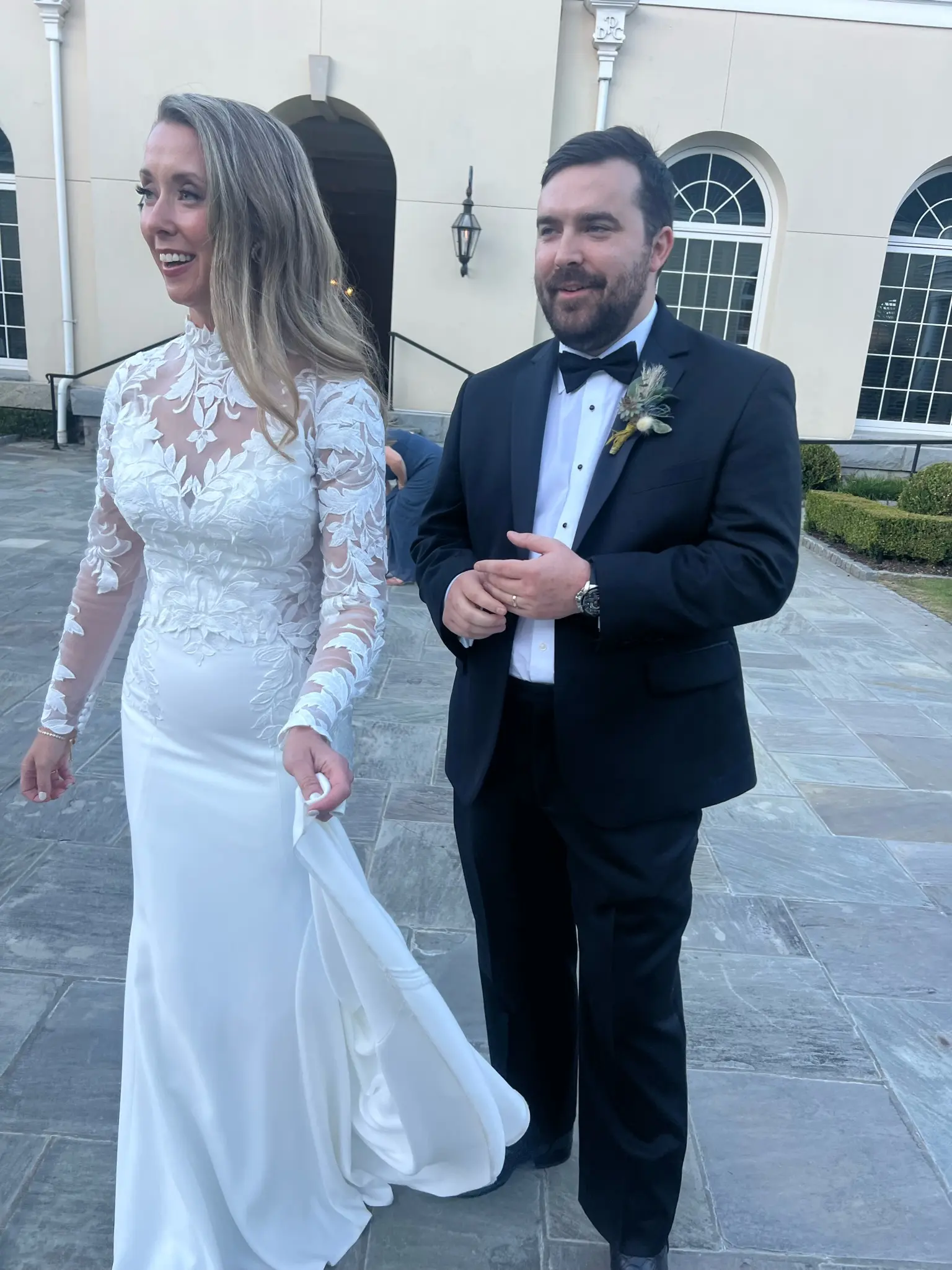 Bride wearing Dionne wedding dress by Rebecca Ingram walking with her husband