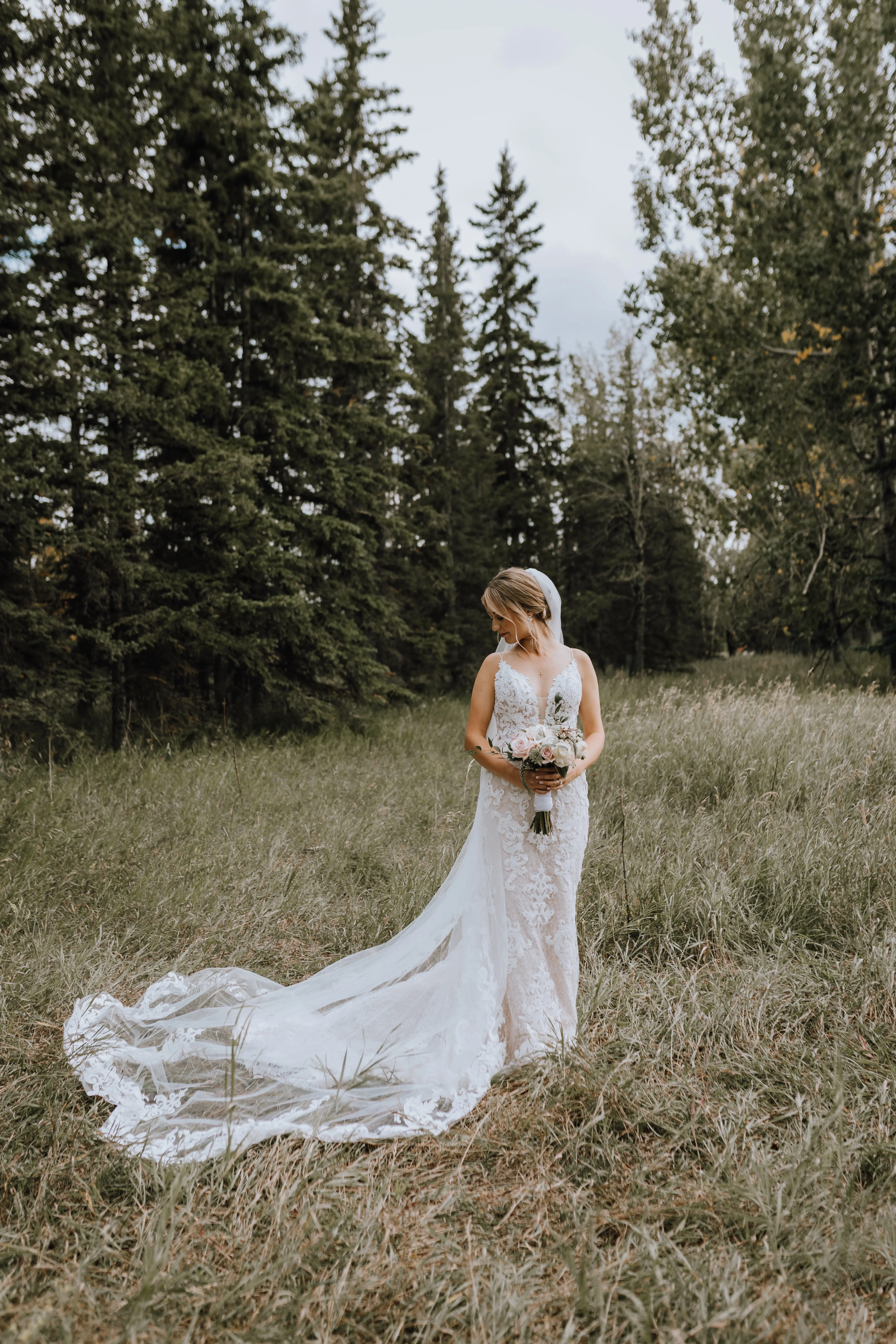 Bride with groom wearing a romantic lace sheath wedding dress.