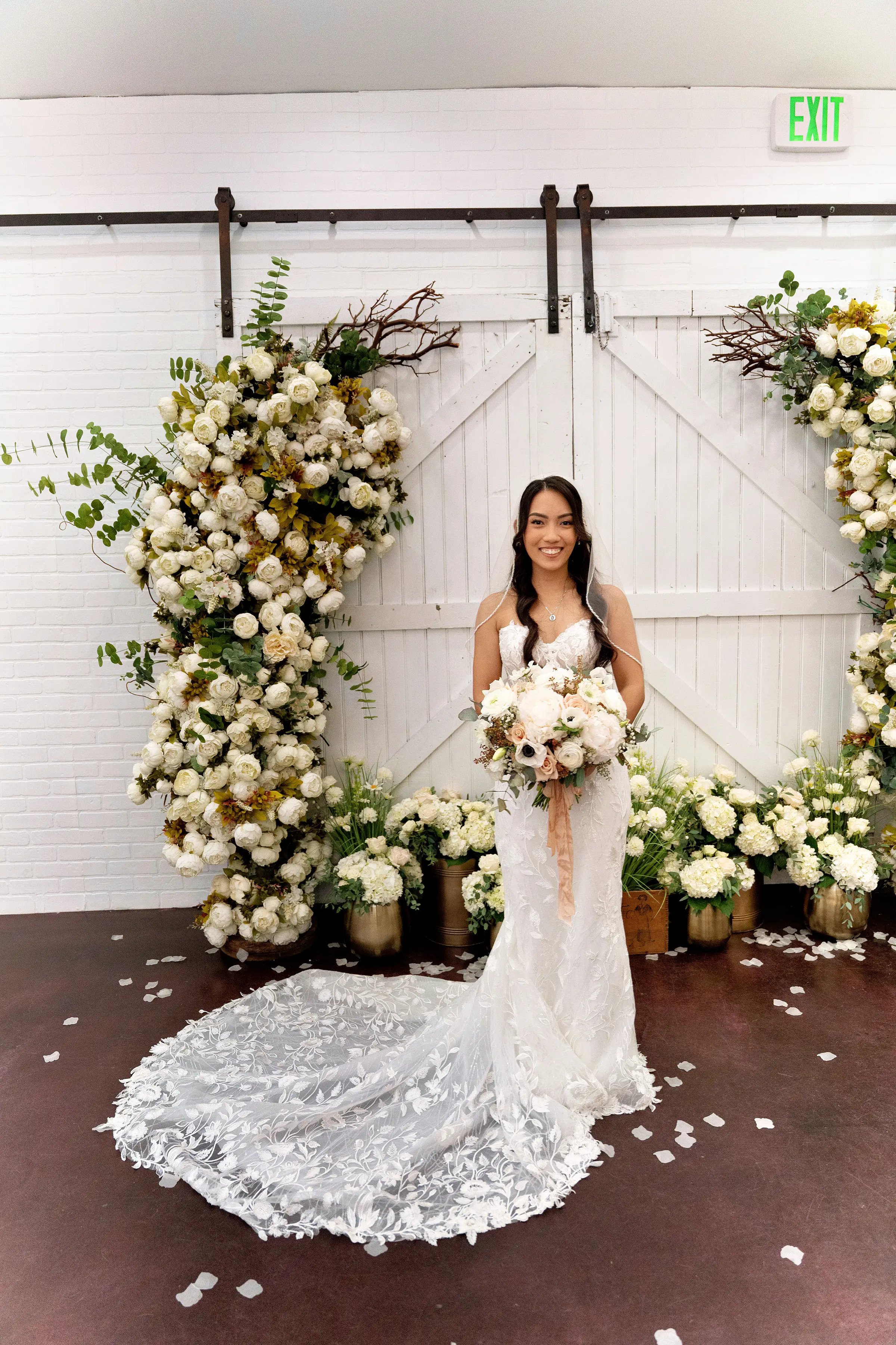 Bride Wearing Lace Fit And Flare Wedding Dress Called Fairchild By Maggie Sottero Next To The Flower Arch