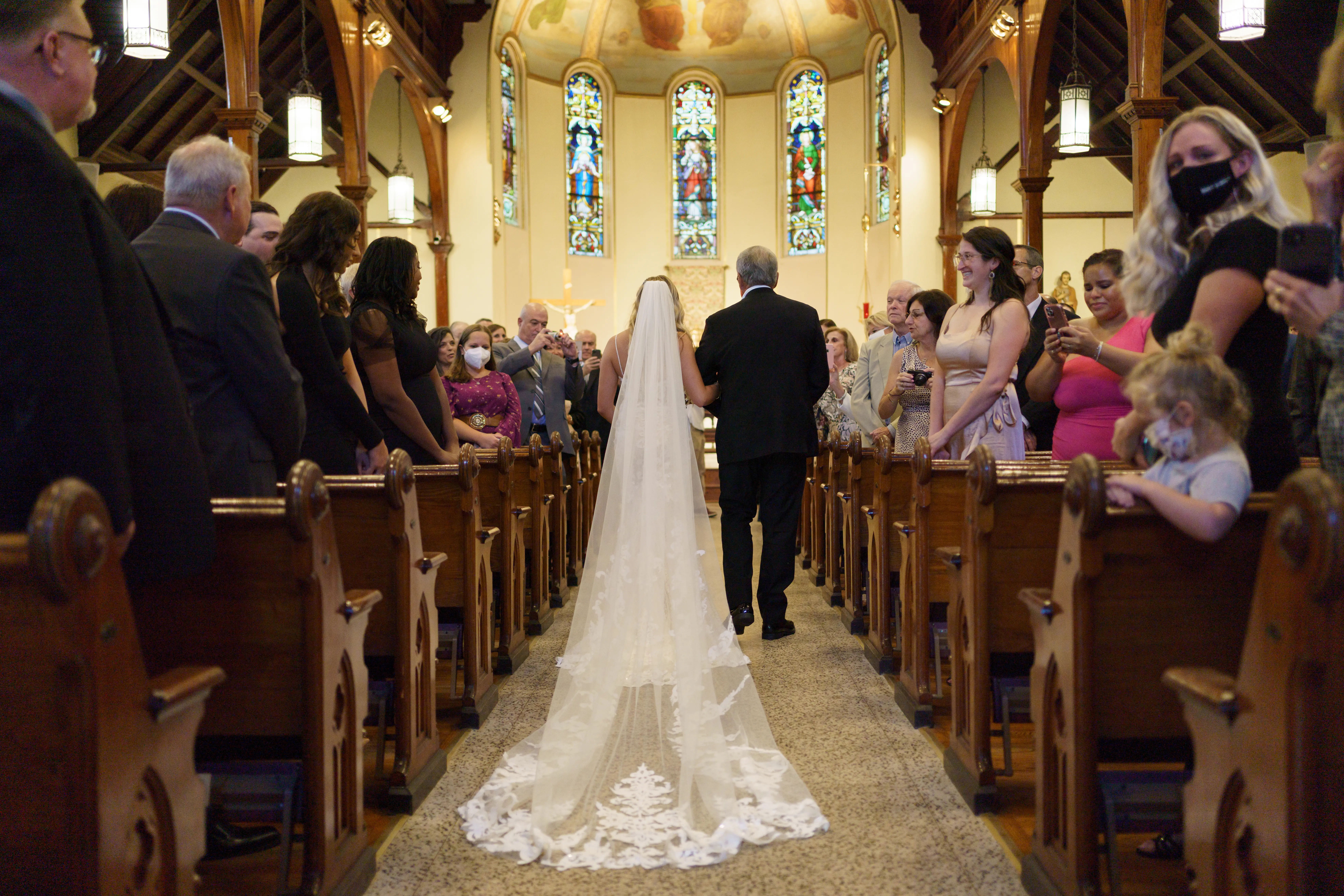 Bride wearing Lace Sheath Wedding Dress called Tuscany Lynette by Maggie Sottero walking down the aisle