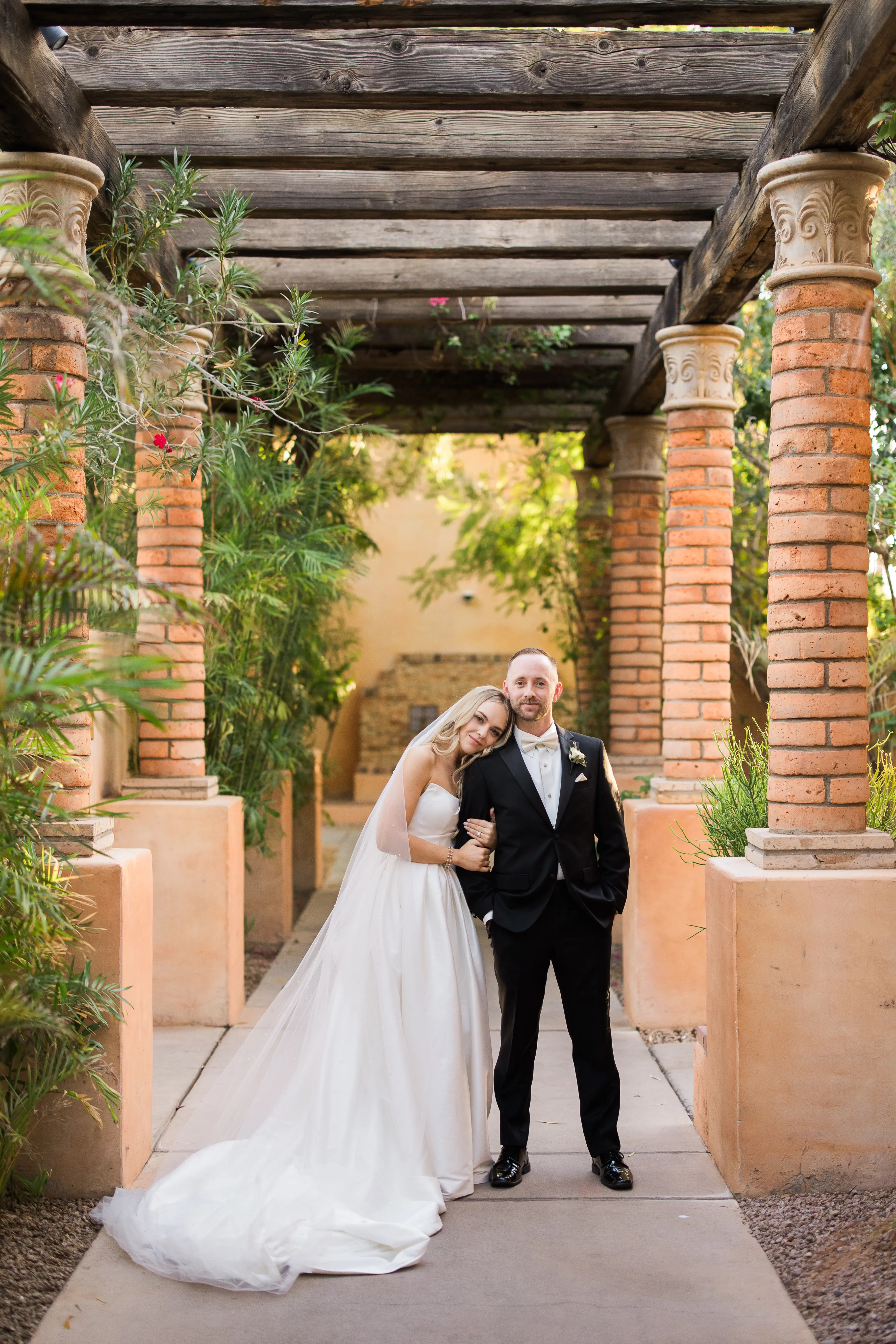 Bride wearing Aspen wedding dress by Sottero and Midgley with her head on her husband's shoulder
