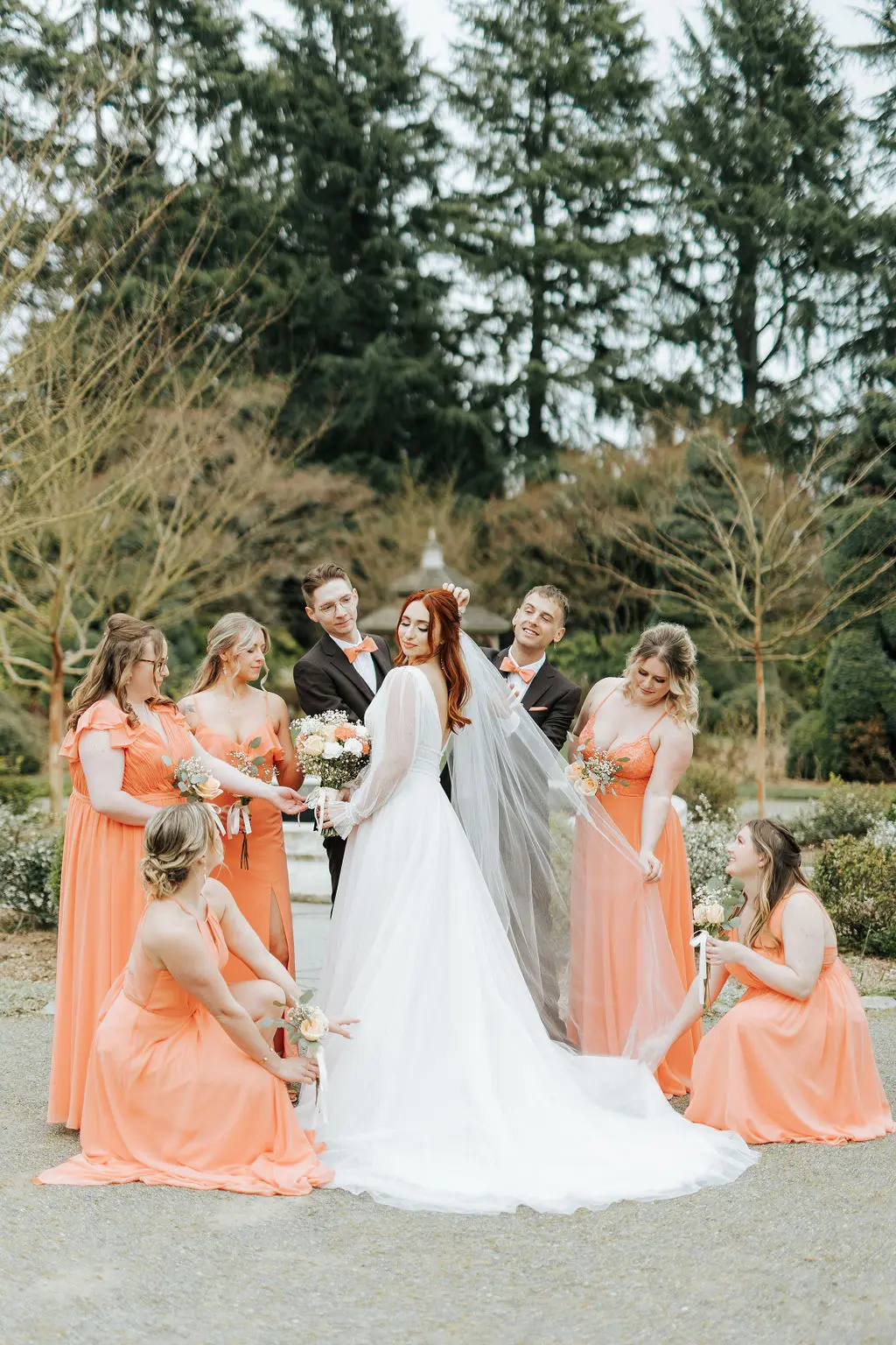 Bride Wearing Sparkly Long Sleeve A-Line Wedding Dress with Bridesmaids Outdoors.