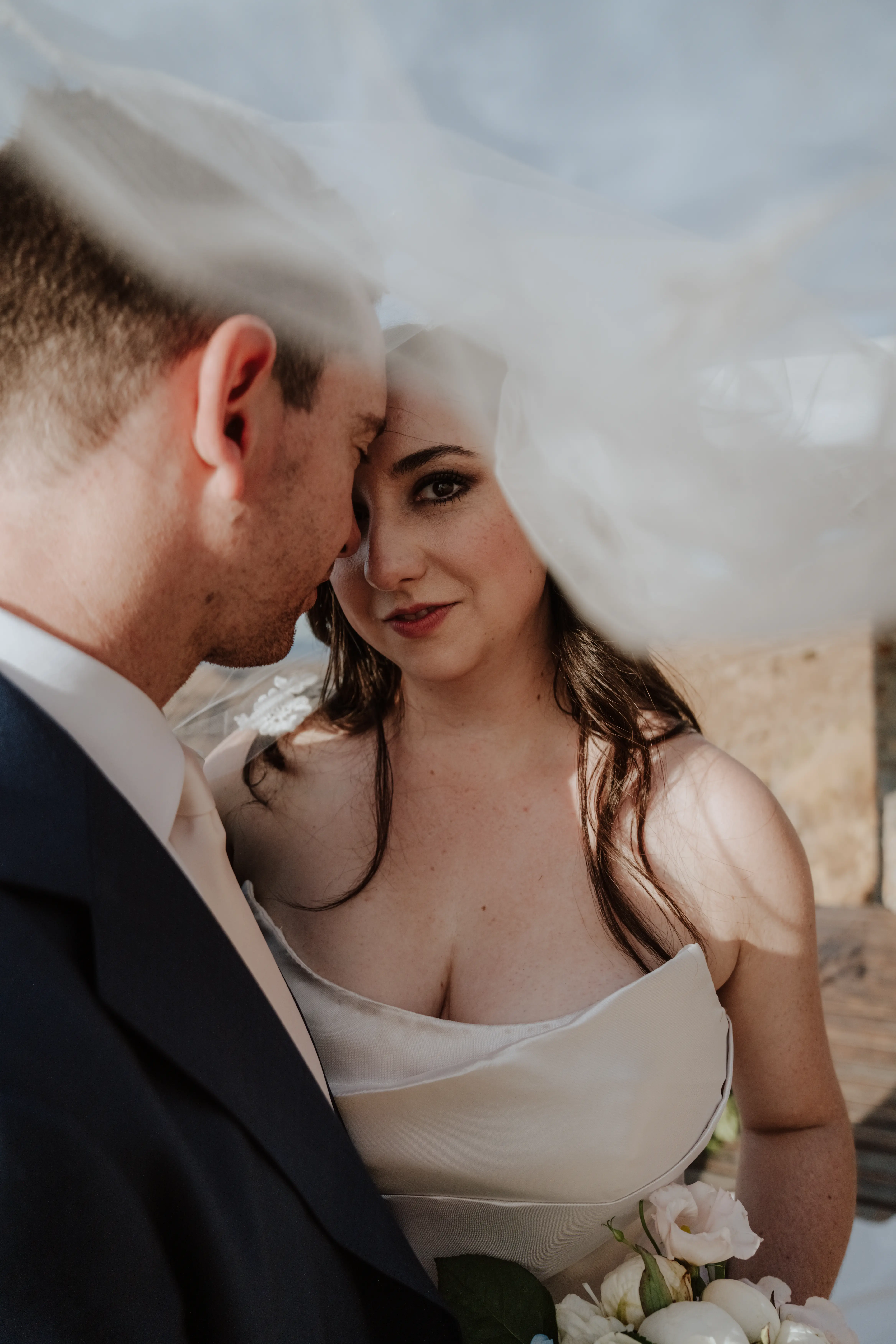 Bride wearing Aspen by Sottero and Midgley under her veil with her husband