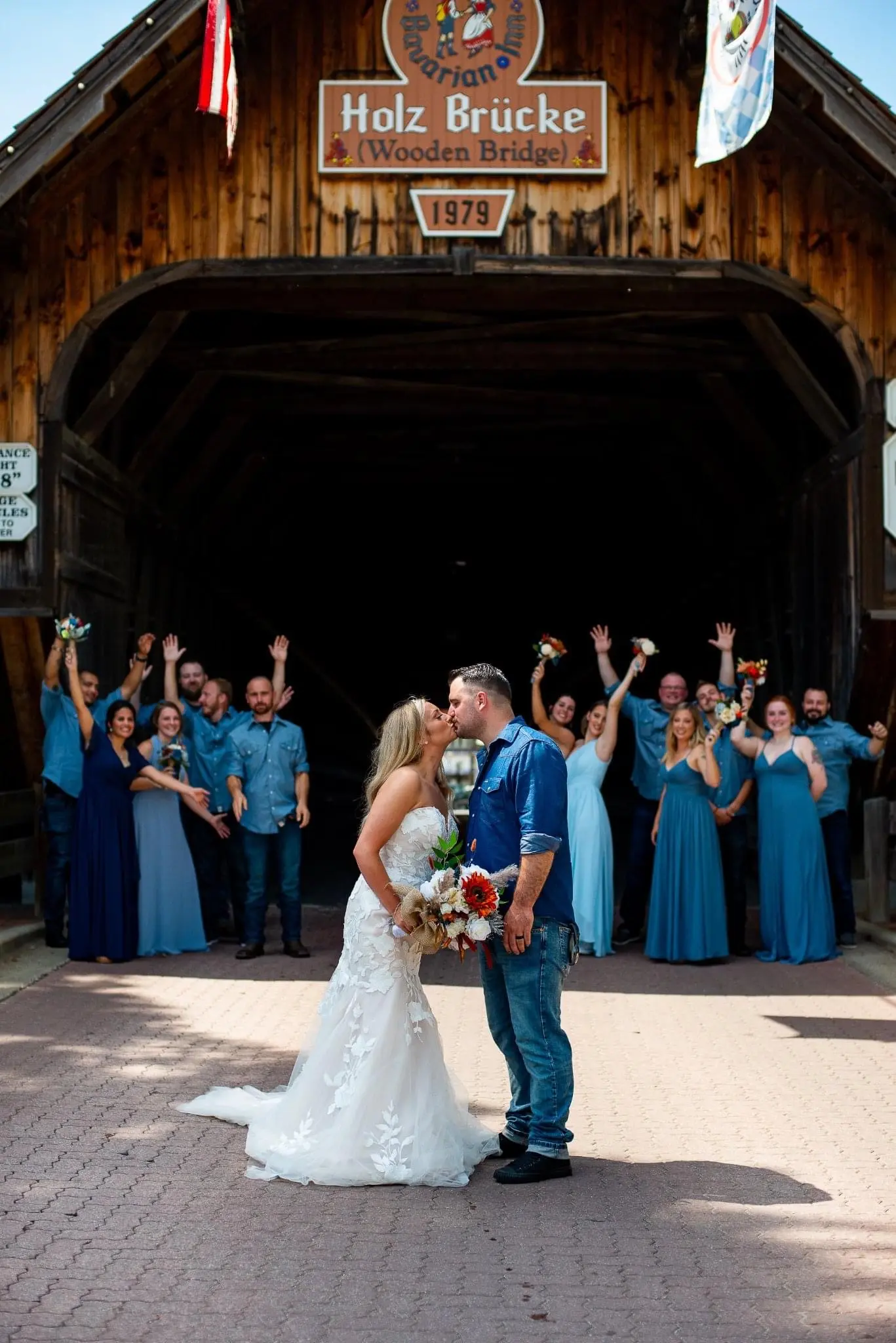 Bride Wearing Lace Strapless Mermaid Wedding Dress Called Hattie By Rebecca Ingram Kissing Groom By Covered Bridge