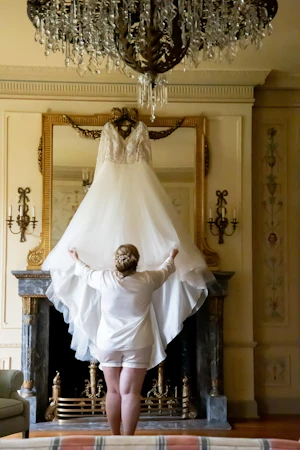 Bride Looking at Hanging Wedding Dress Called Mallory Dawn by Maggie Sottero
