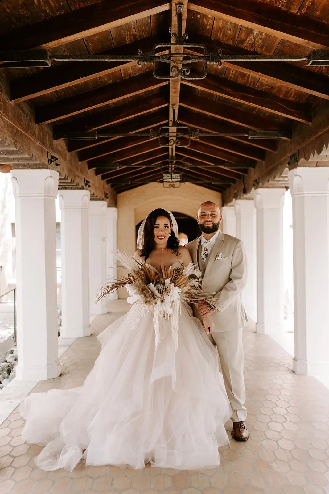 Bride with groom wearing strapless tulle ballgown wedding dress