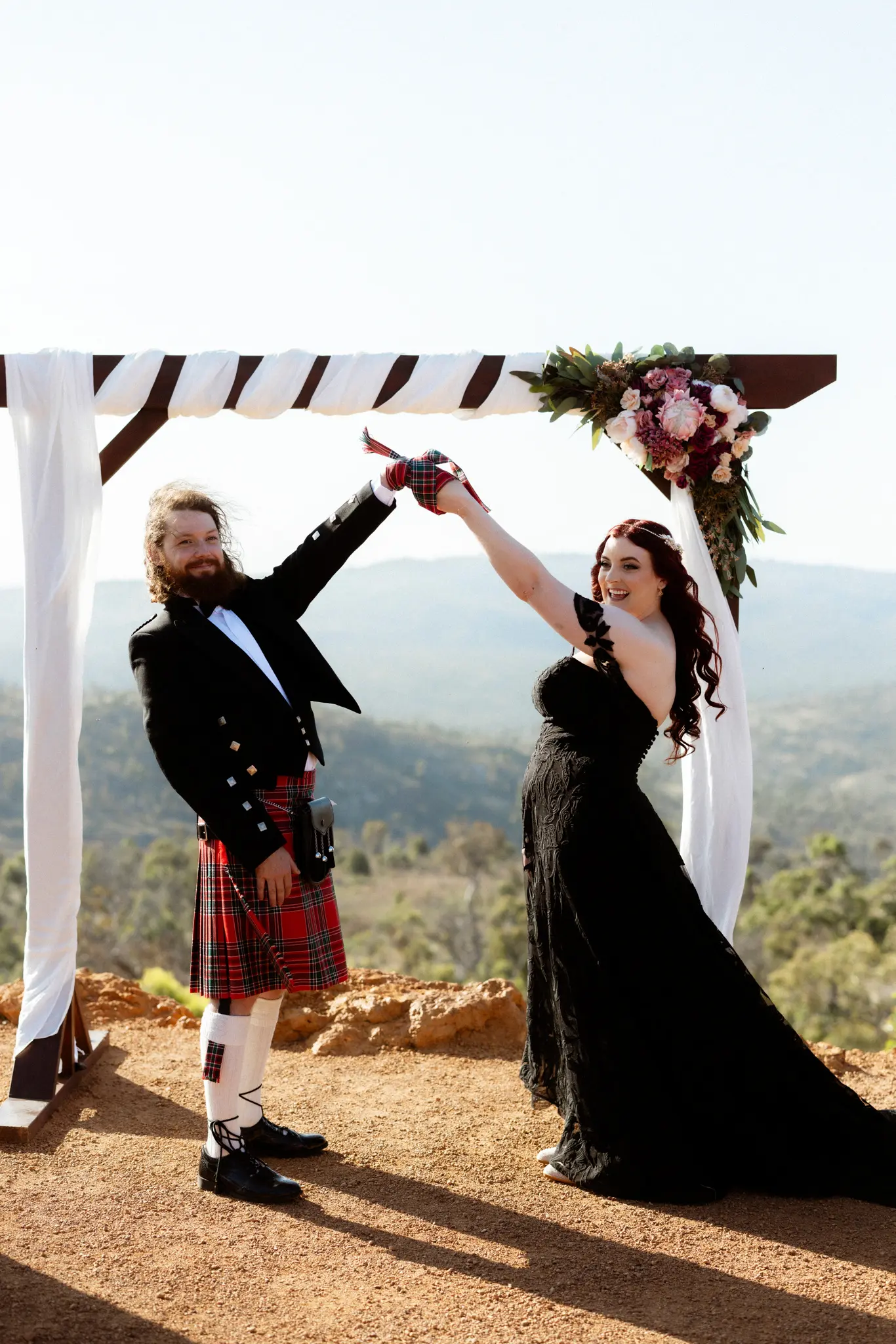 Bride Wearing Black Lace Wedding Dress Called Penny By Maggie Sottero And Groom Near an Altar