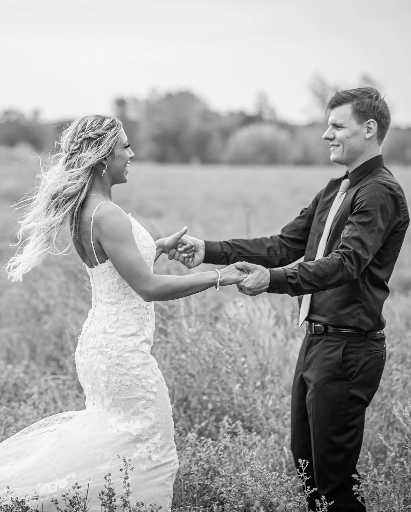 Bride with groom wearing romantic lace sheath wedding dress.