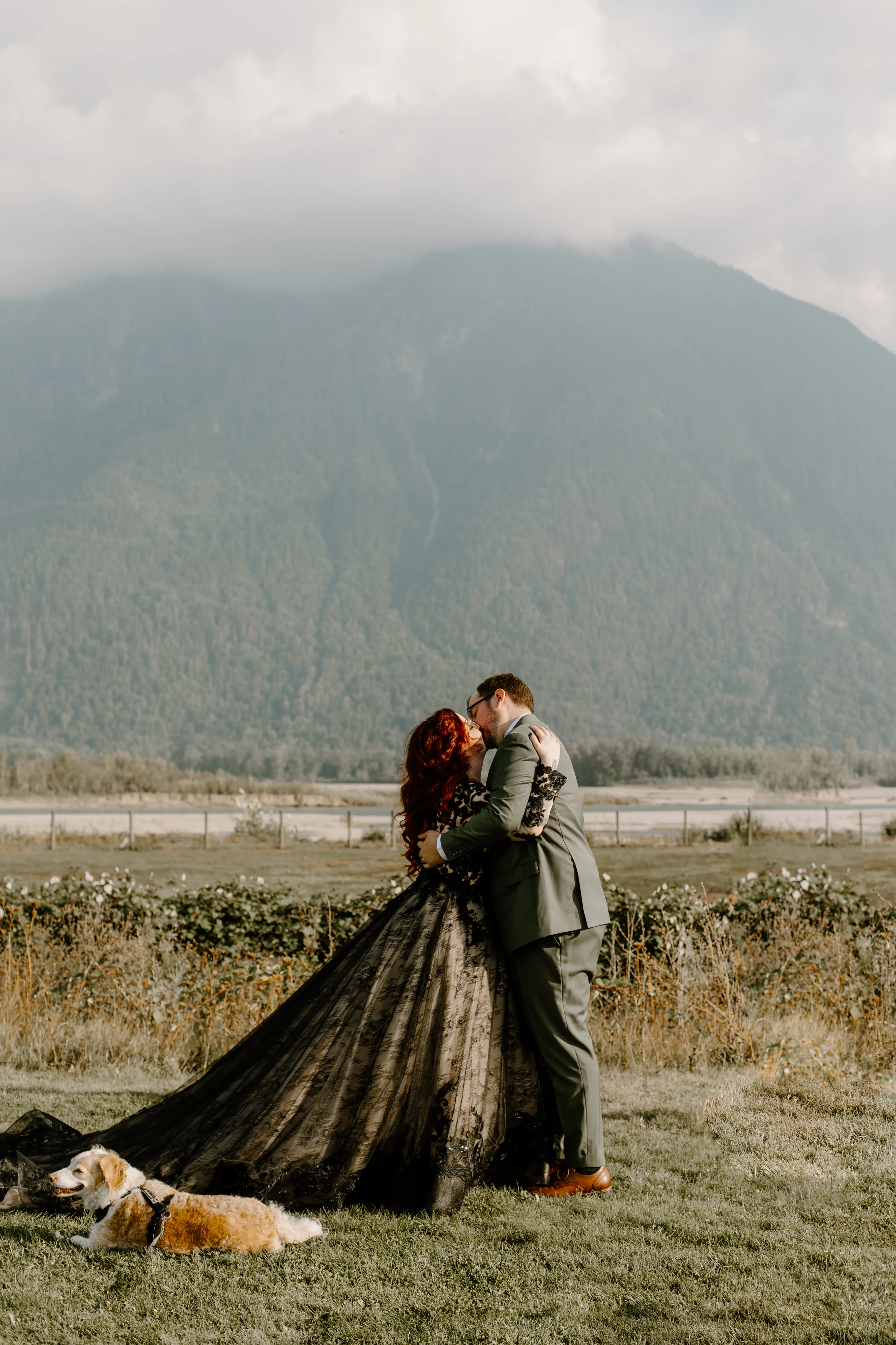 Bride Wearing Black Wedding Dress Zander By Sottero and Midgley Kissing Groom In A Field