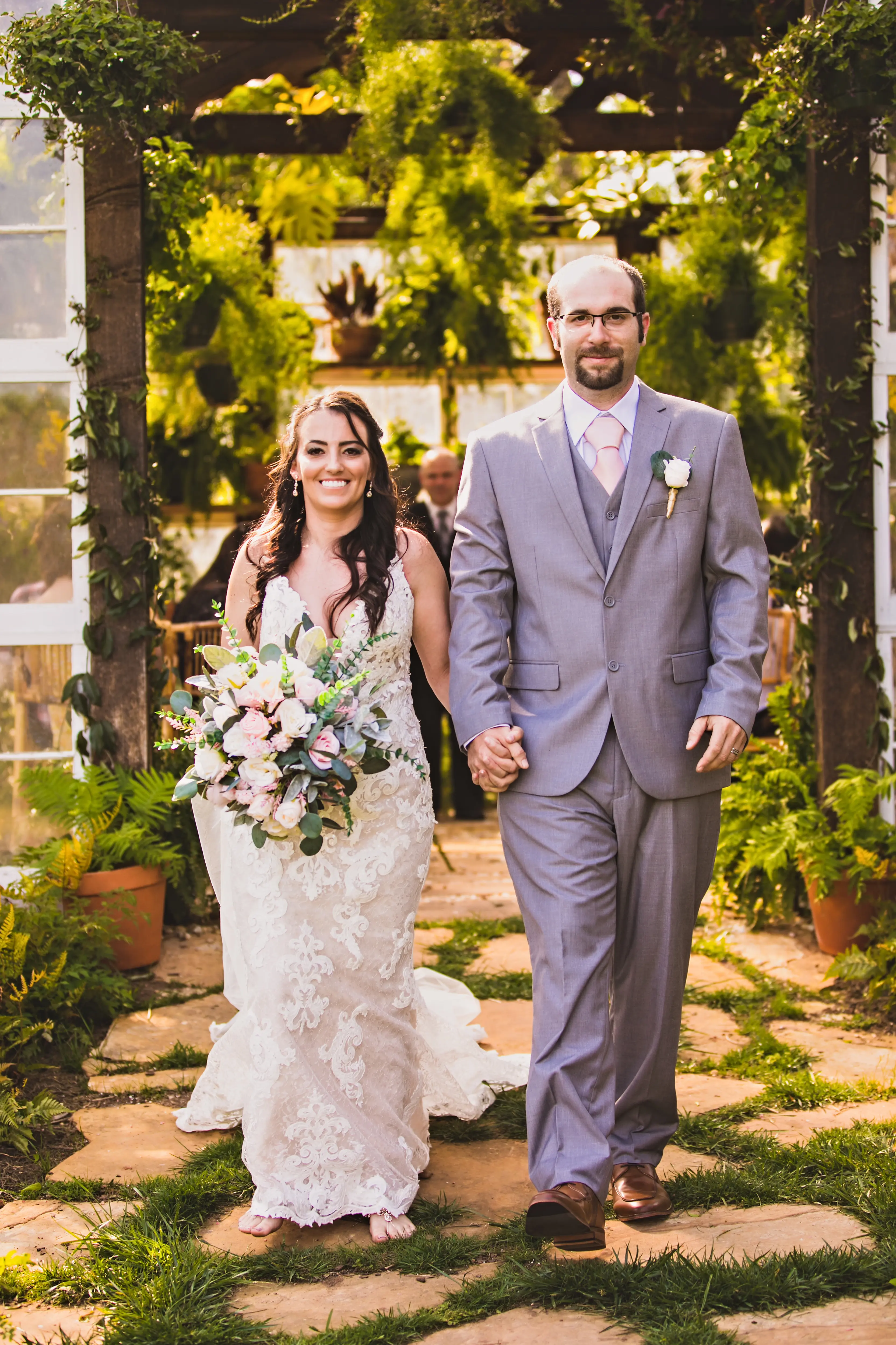 Groom Holding Hands with Bride in Shimmering Lace Motif Wedding Gown with Plunging Sweetheart Neckline Called Tuscany Lynette by Maggie Sottero