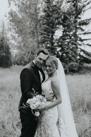 Bride with groom wearing a romantic lace sheath wedding dress.