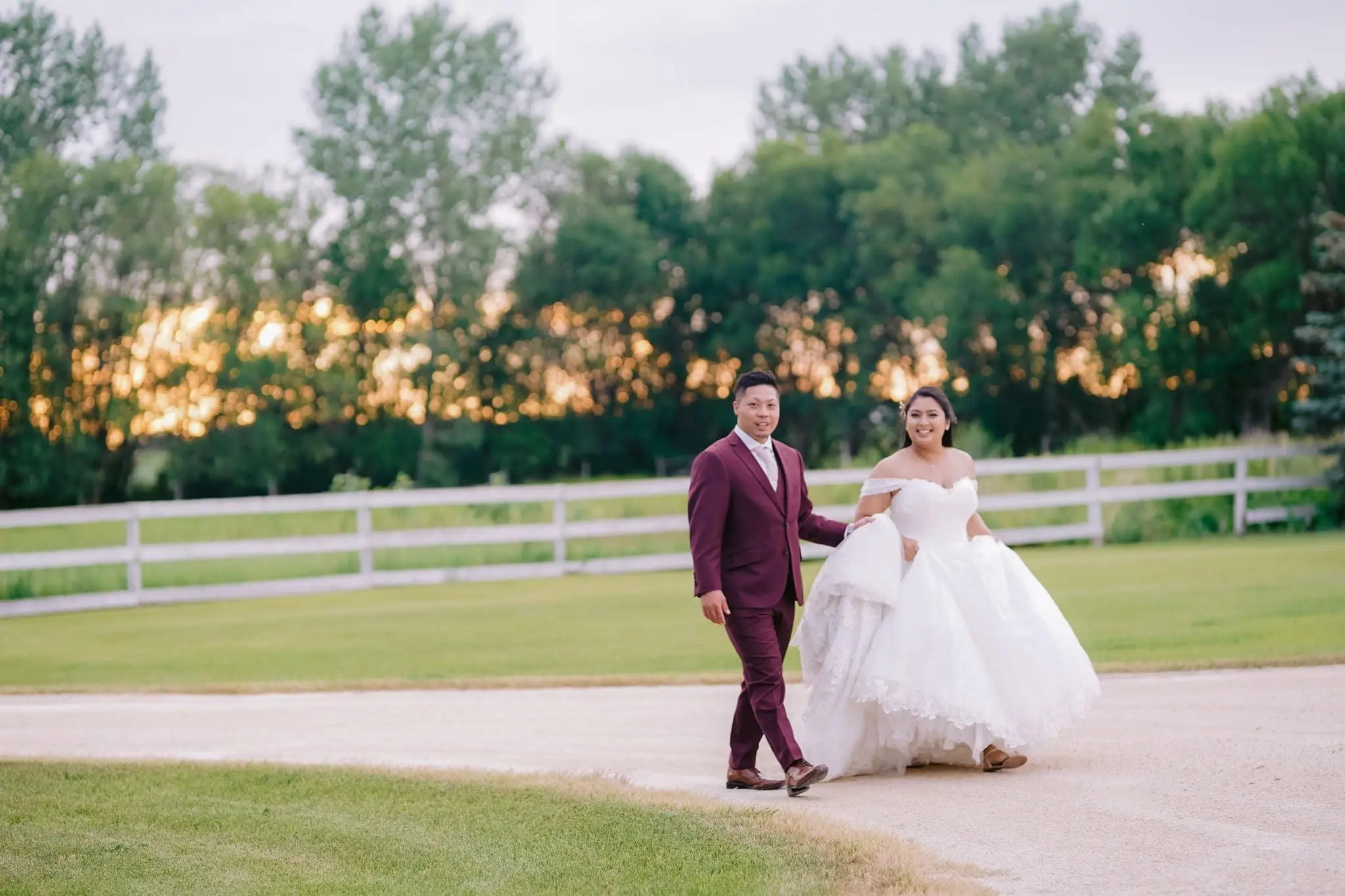 Groom holding bride's train of wedding dress called Tristyn.