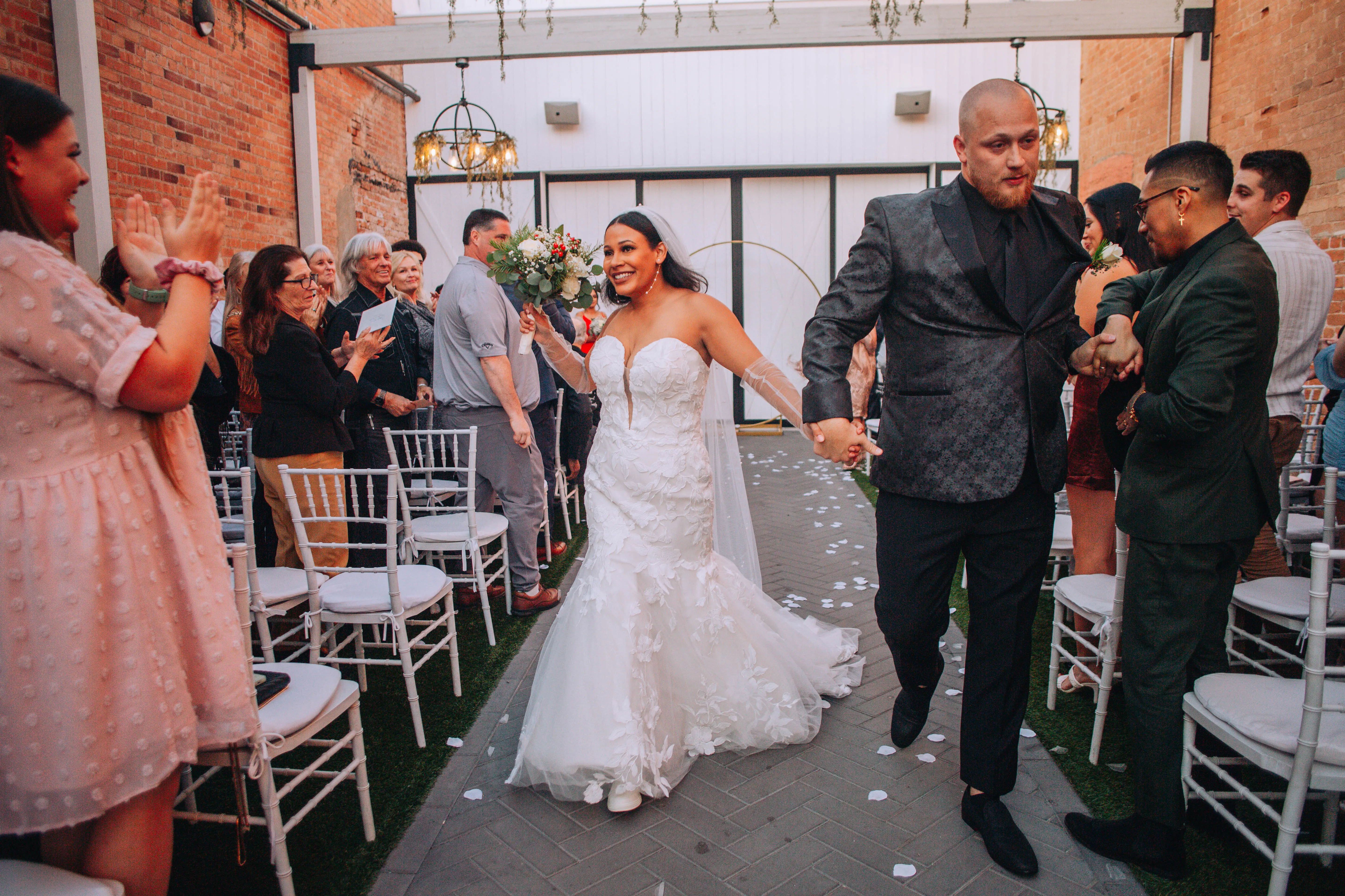 bride in sexy mermaid wedding dress called hattie by rebecca ingram with groom down aisle