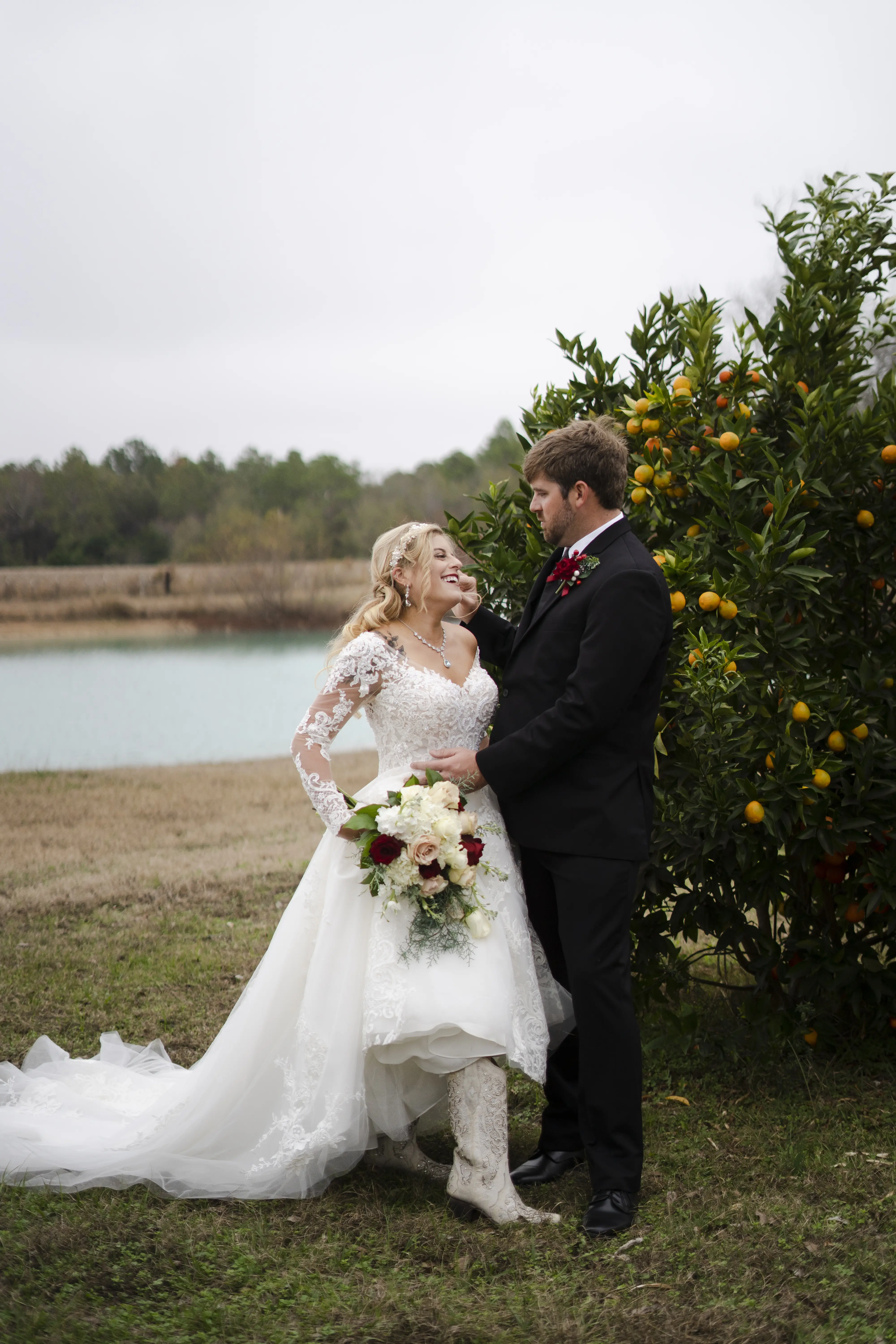 Bride In Off The Shoulder Lace Wedding Dress Called Tiffany By Maggie Sottero With Groom And Cowboy Boots