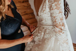 Bride Wearing Long Sleeve Lace Wedding Dress Called Raphael By Maggie Sottero Getting Buttoned Up