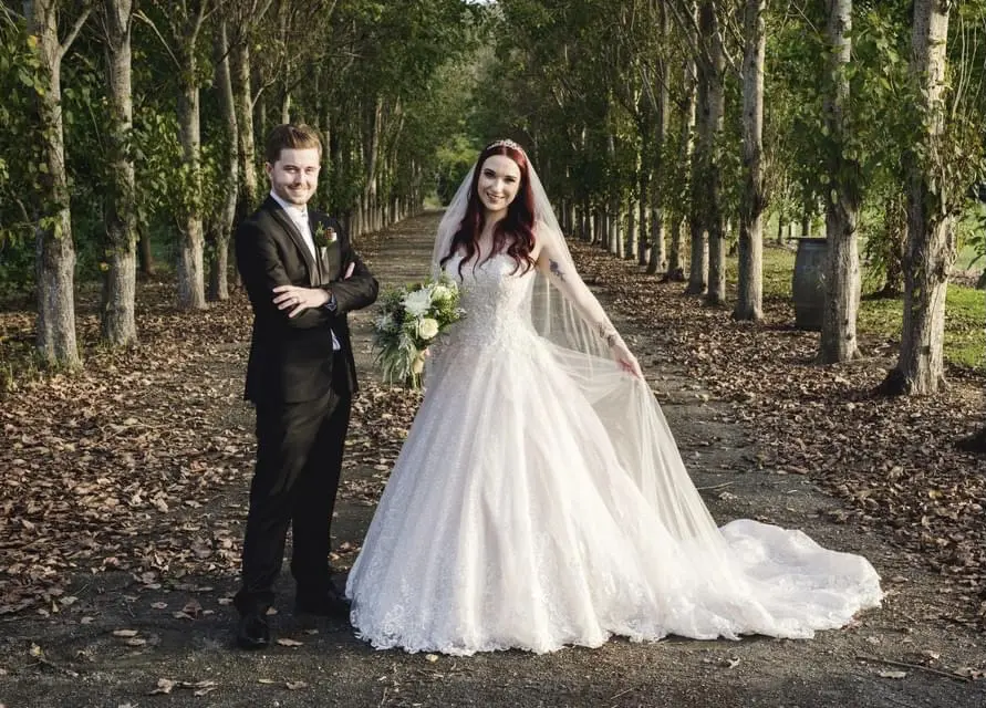 Groom with Bride in Lace Ball Gown Wedding Dress with Sequined Tulle and Lace Motifs over Bodice and Statement Hemline called Tristyn by Maggie Sottero
