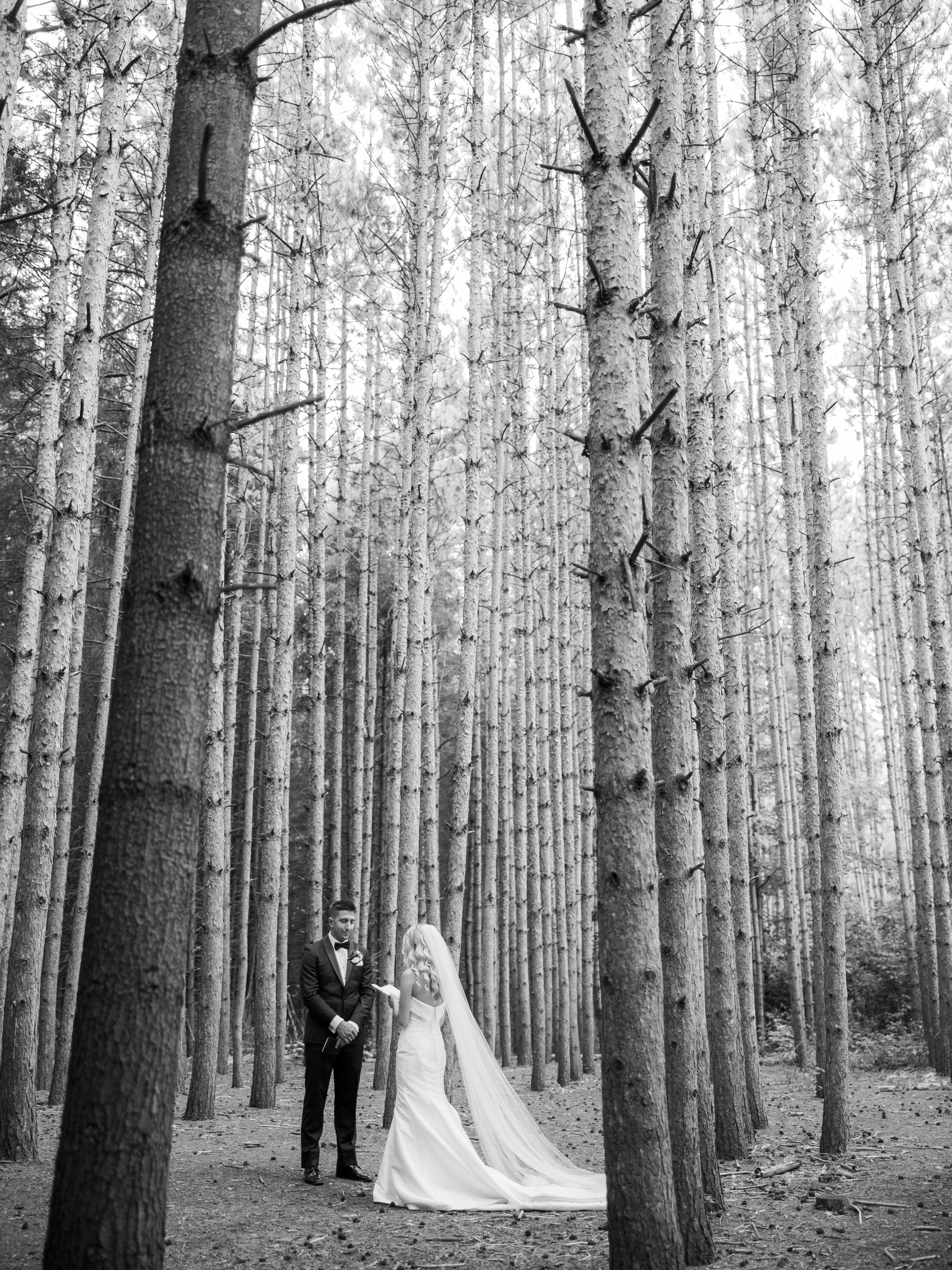 Bride Wearing Simple Fit And Flare Wedding Dress Called Mitchell Marie By Maggie Sottero Reading Vows To Groom In The Forest