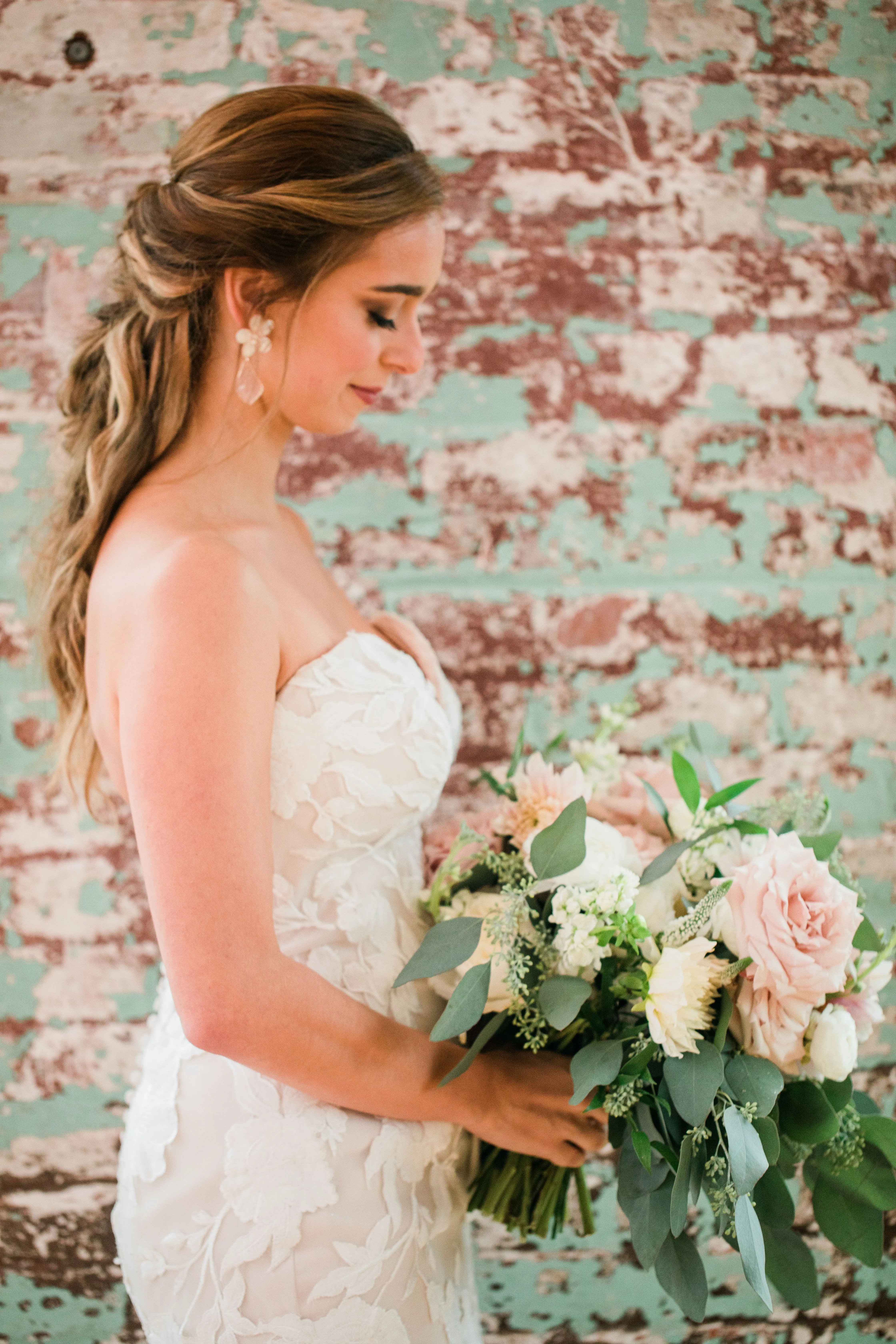Bride wearing strapless mermaid wedding dress with oversized lace