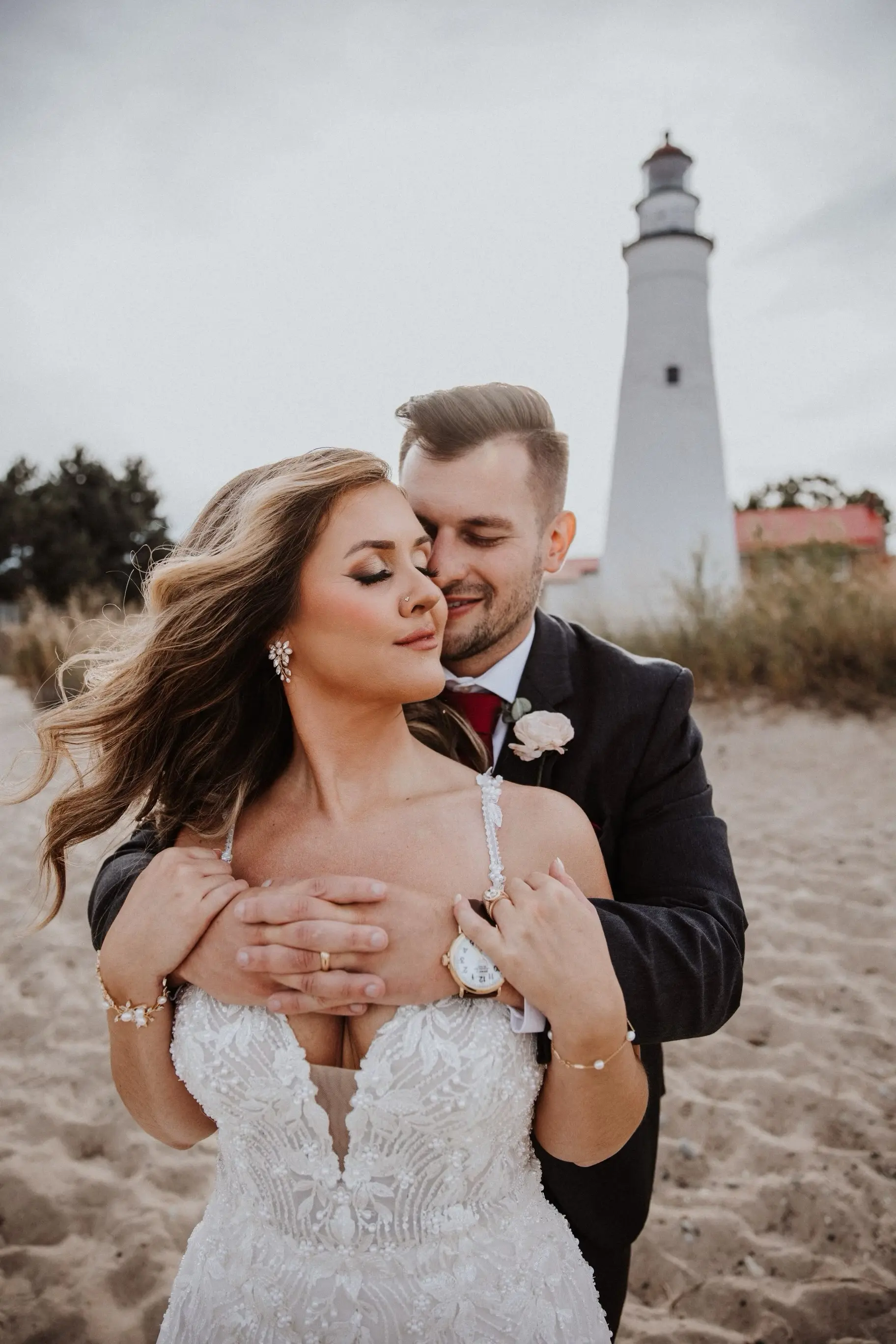 Bride Wearing Beaded Fit-n-flare Wedding Dress Called Jonah Lane By Sottero And Midgley With Groom Next To A Lighthouse