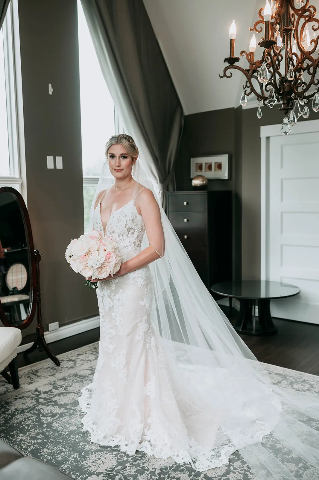 Bride holding light pink and ivory bouquet wearing wedding dress called Tuscany Lynette.